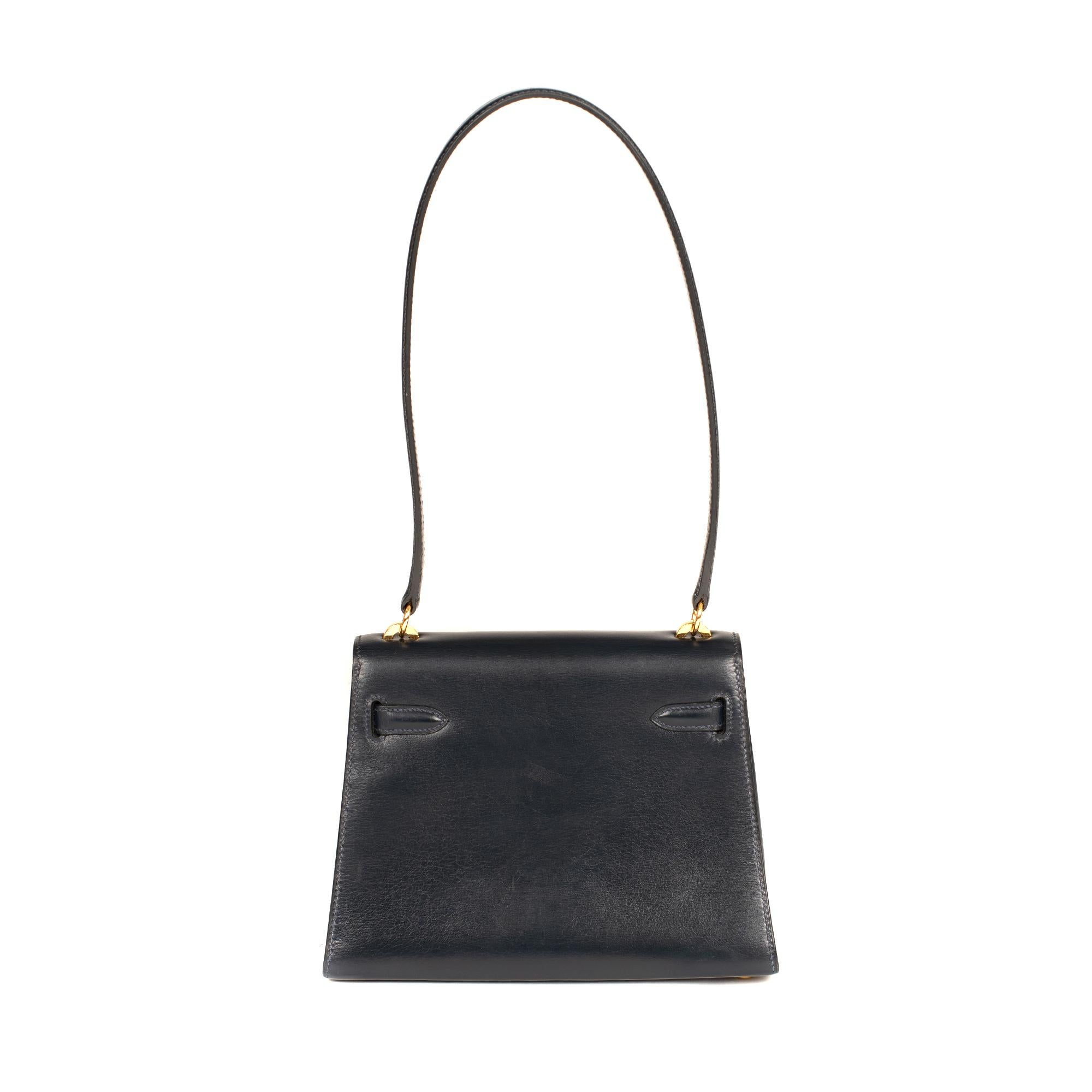 Stunning Hermes Mini Kelly handbag 20 cm in navy blue box leather, gold-plated metal hardware, navy blue leather handle allowing a hand or shoulder wear.

Closure on flap.
Lining in blue leather, one patch pocket.
Signature: 