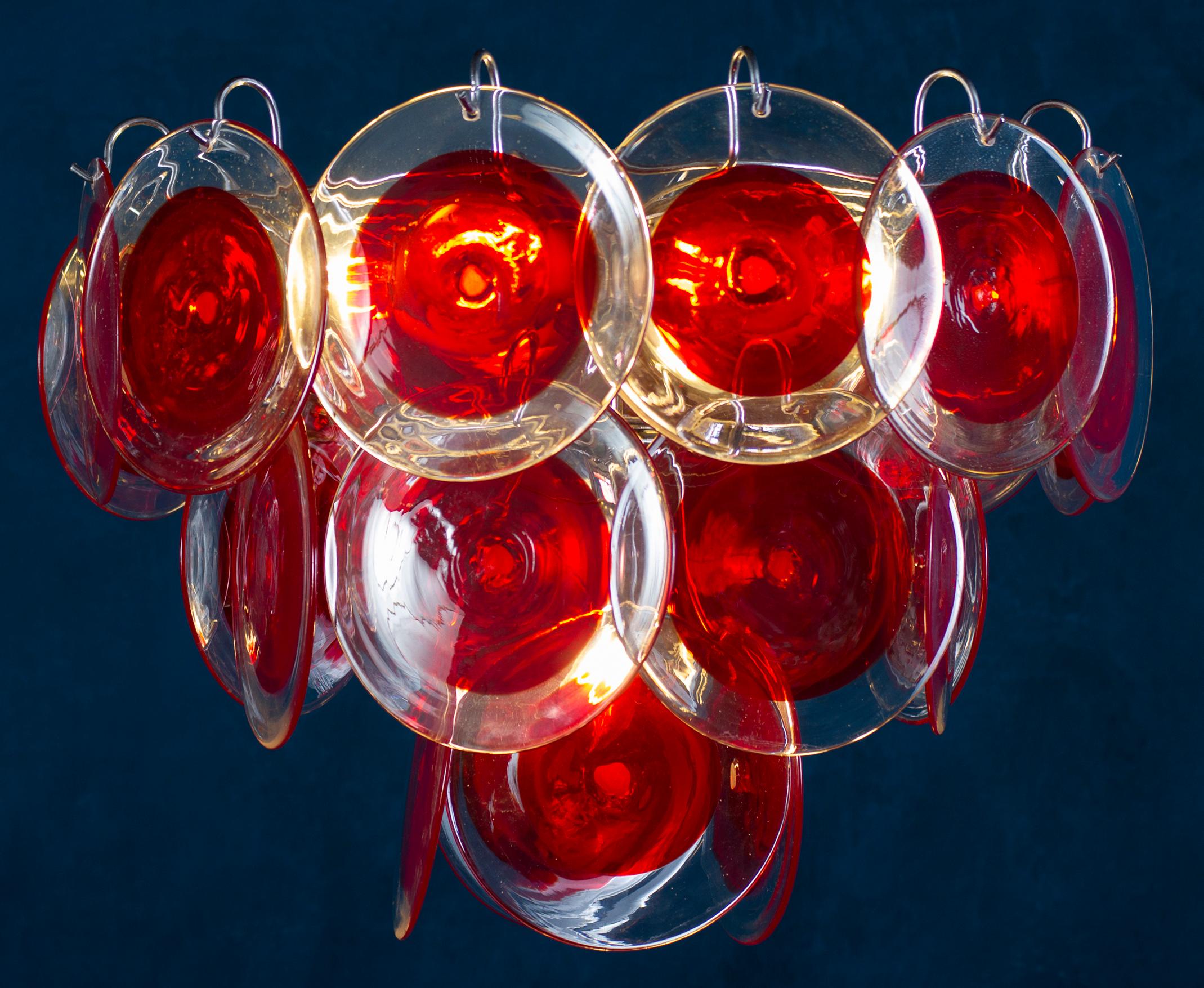 The 24 red discs of precious Murano glass are arranged on three levels. 
Nine E 14 light bulbs. Height without chain 40 cm.
Available also a pair.