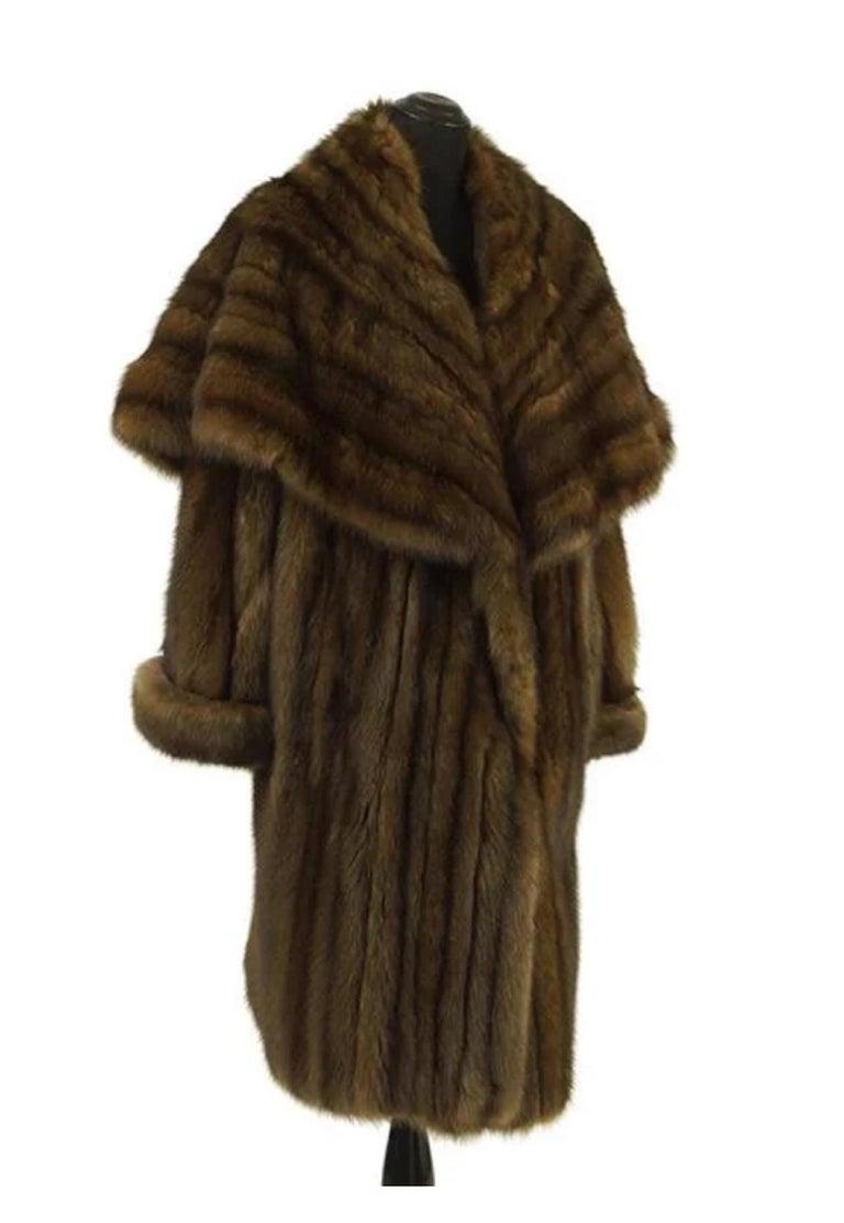 A Russian sable coat.

Double breasted 7/8 sable coat with fold over cuff and a cape collar that can be worn closed around the neck or lower around the bust line. Labeled 