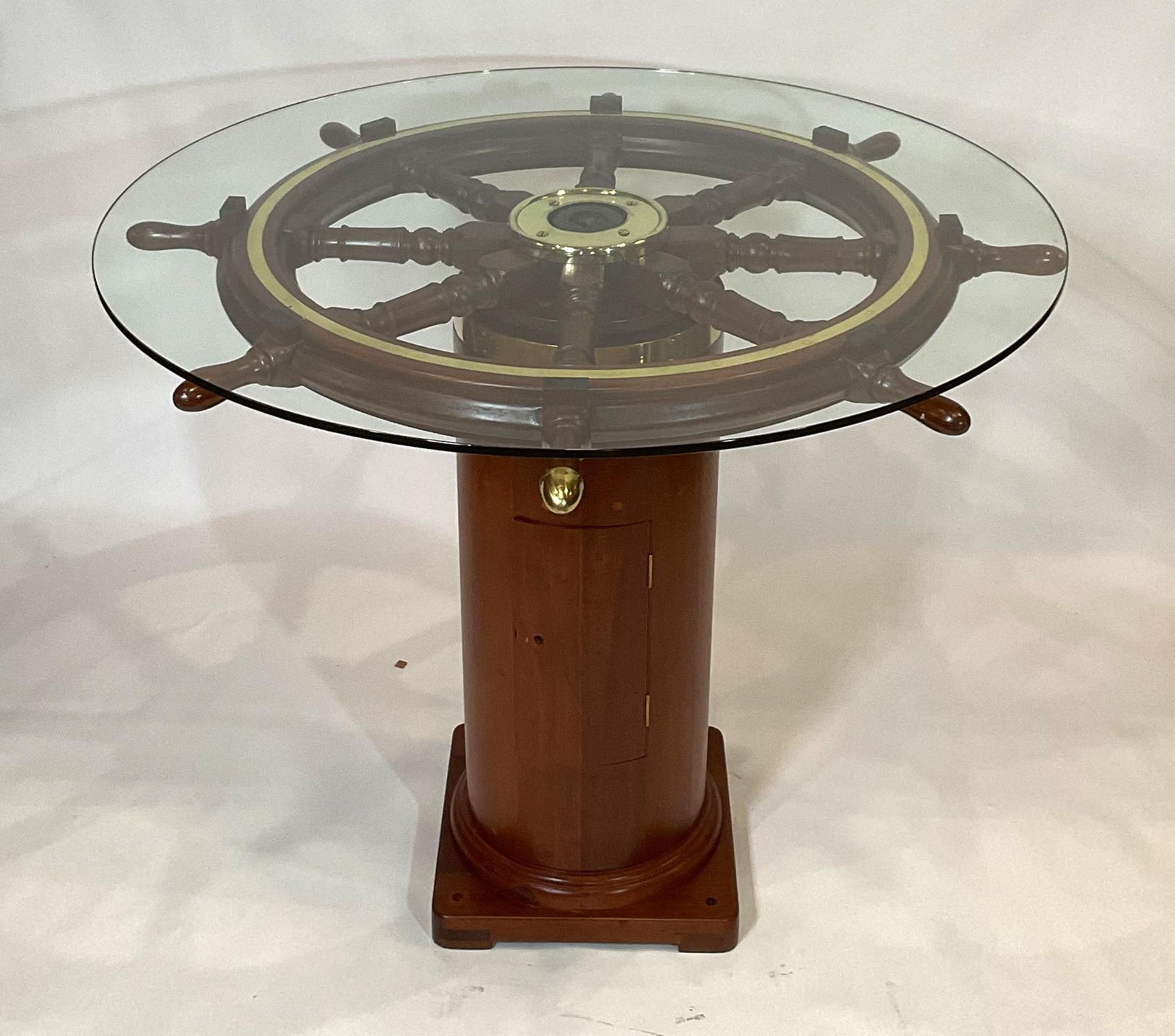 Quality antique ships wheel mounted to an authentic ships binnacle base creating a spectacular bar height pub table. The early Twentieth Century eight spoke wheel has been expertly refinished. The brass hub trim and outer brass band are meticulously