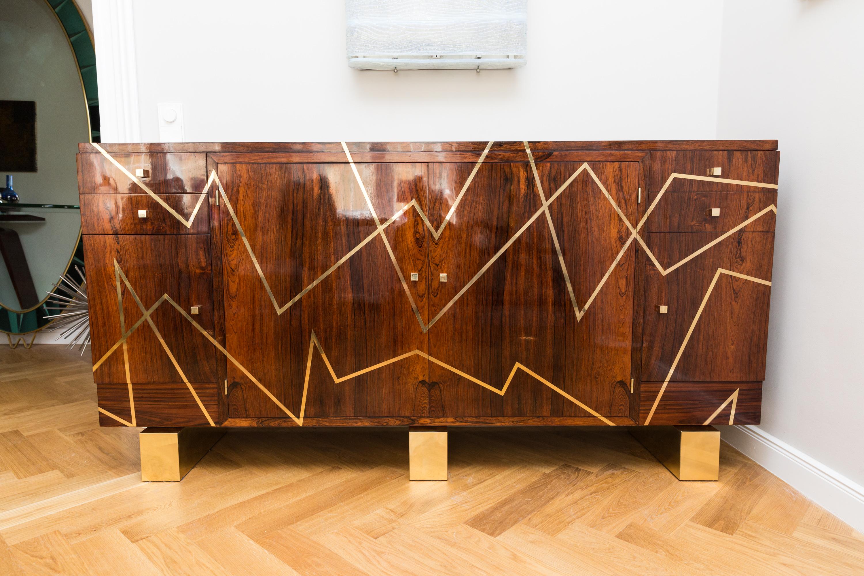 Very elegant sideboard, France, circa 1950, rare single piece marquetry in brass, rosewood front, side parts and top with brass throughout different brass lines. Heavy brass feet, massive brass handles in cube shape, two small drawers left and