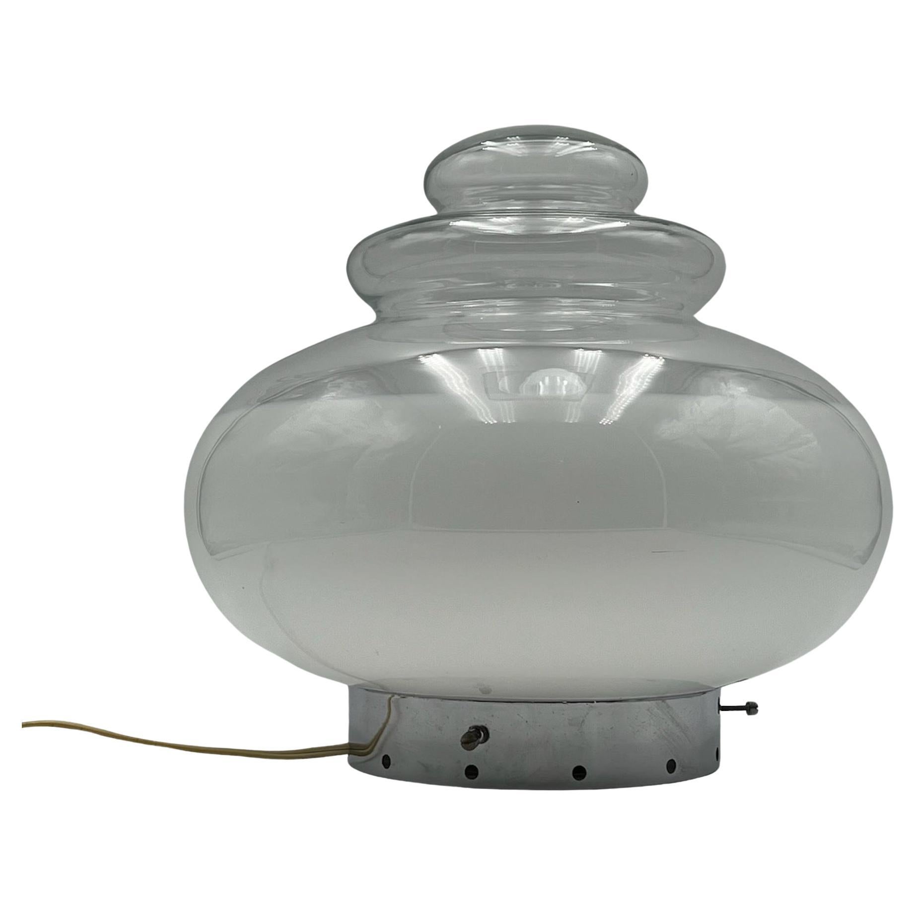 Large and impressive table lamp with the iconic 'flying saucer' shape typical of late 60s / early 70s creations.

This lamp is made of a perfectly crafted base made of chromed metal with authentic bolts. The big lampshade made of glass with opaline