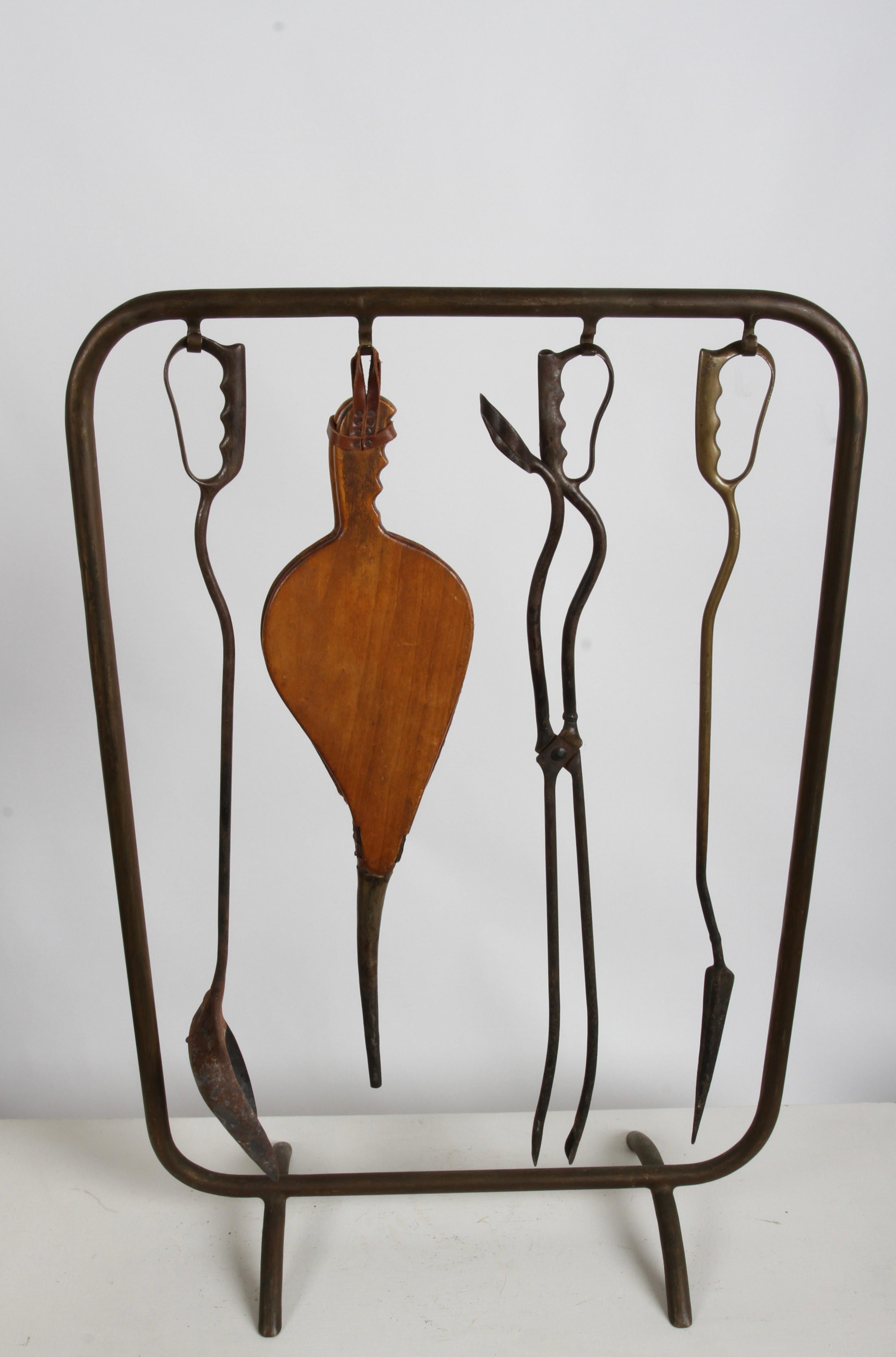 Very unique, possible one of a kind Artisan made hand wrought, 1950s Italian fireplace tools and stand. Set consist of tubular brass stand, that the tools hang from. Set includes the shovel, wood bellow, thongs and bronze poker. An unusual feature