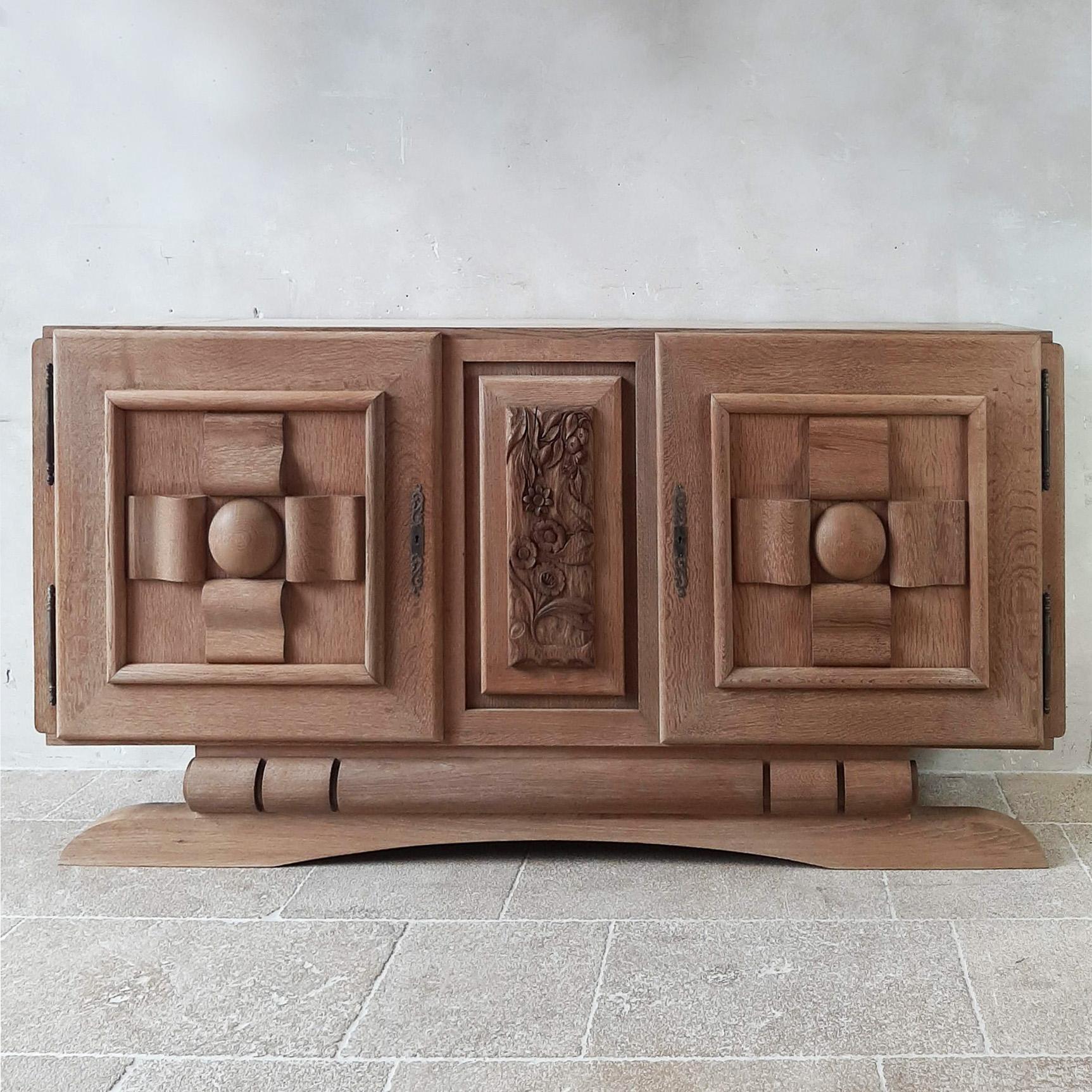 Amazing vintage design sideboard by Charles Dudouyt in solid bleached oak, 1950s. The doors of this stunning and sturdy sideboard are cut in graphic and geometric shapes and the center panel has a beautiful wood carving in floral print.

dimensions: