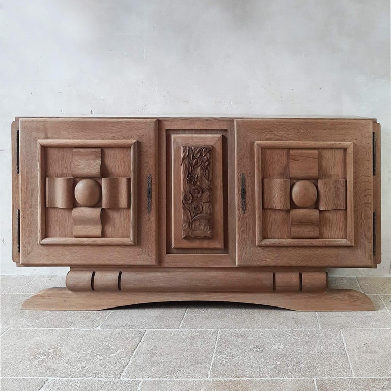 Amazing vintage design sideboard by Charles Dudouyt in solid bleached oak, 1950s. The doors of this stunning and sturdy sideboard are cut in graphic and geometric shapes and the center panel has a beautiful wood carving in floral print.

dimensions:
