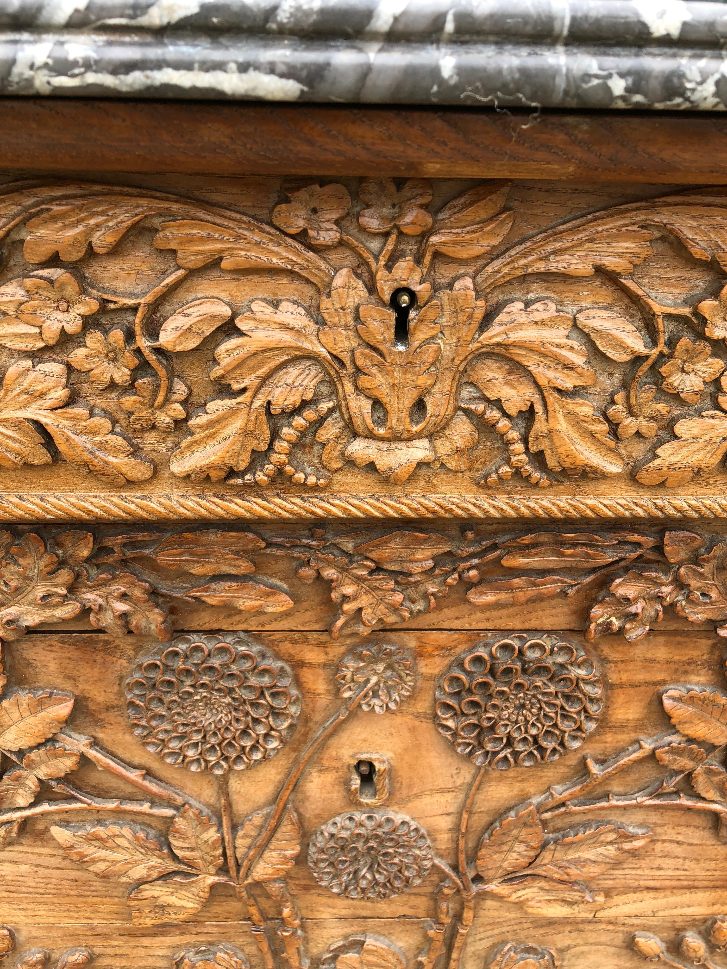 Probably a commissioned piece, this stunningly carved French walnut commode was discovered in the west of France. It has five drawers and the original key with meticulously beautiful floral carvings. One of a kind! Five drawers. Top one flips down.