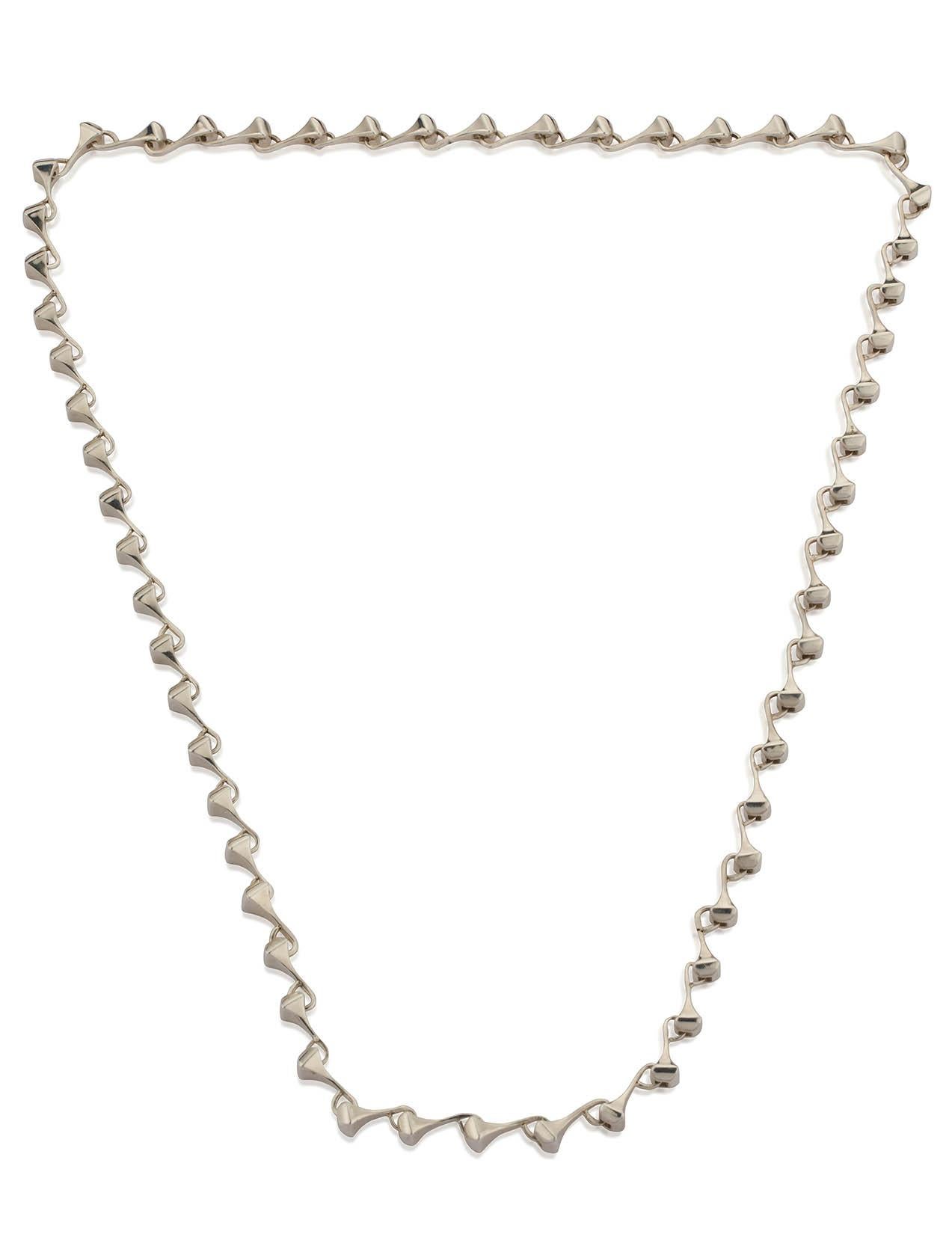 Lange Halskette aus poliertem Sterlingsilber in geschlechtsneutralem Stil
Das Design hat eine Rock'n'Roll-Atmosphäre und ist von der Welt des Pferdesports inspiriert, da die Glieder der Halskette eine Form haben, die an Hufeisennägel erinnert. Auch