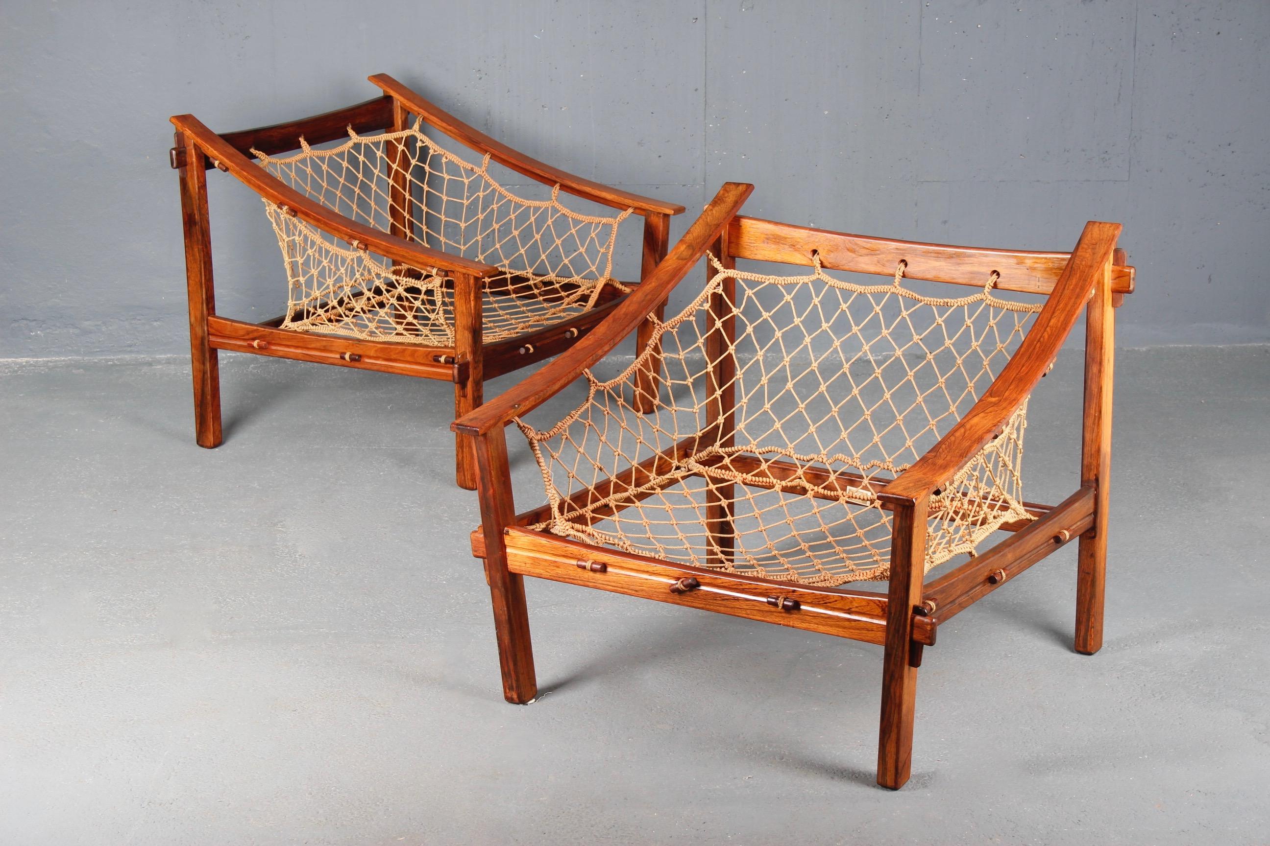 Amazonas pair of Jean Gillon armchairs, a slot on the armrest of one chair.