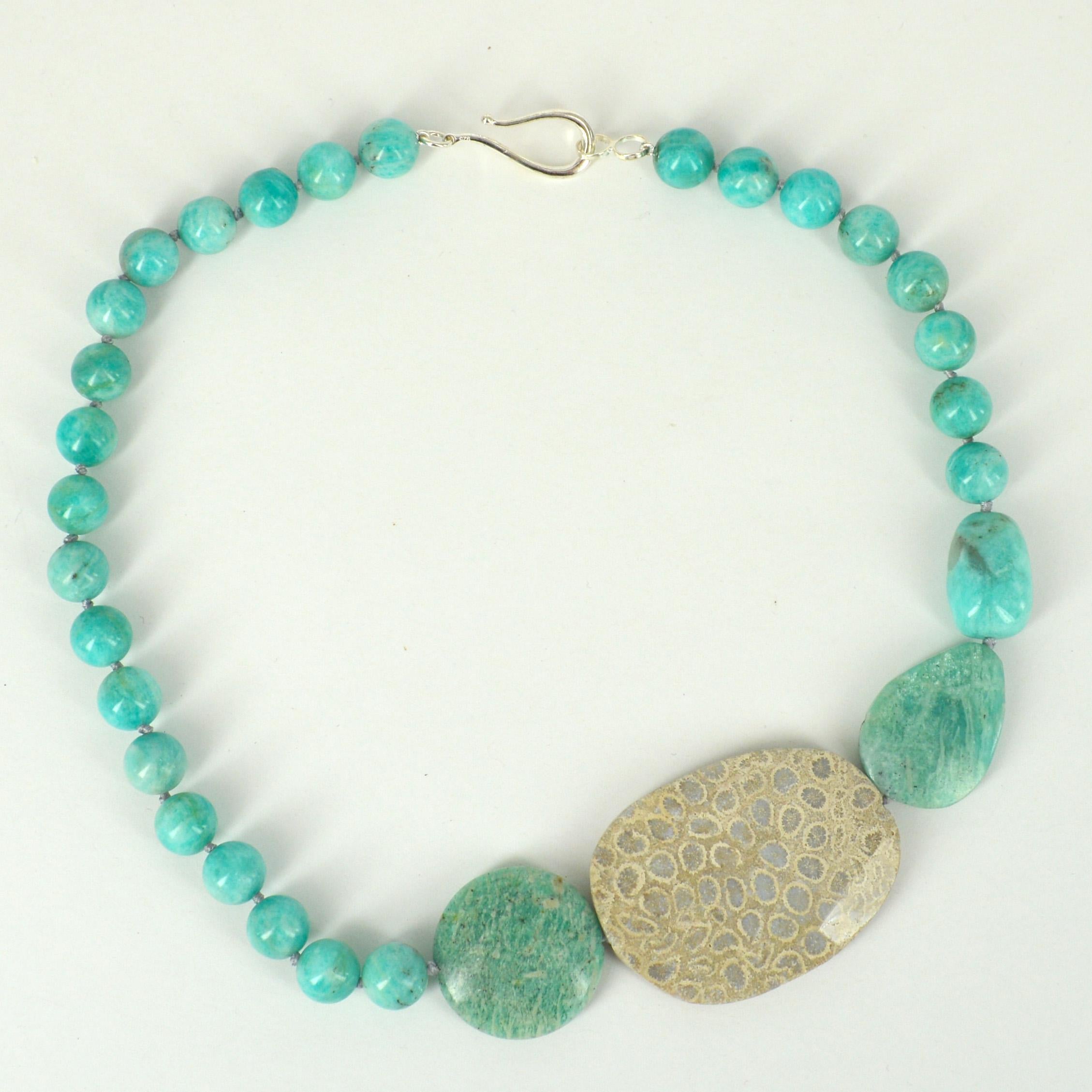 11mm polished round Amazonite beads with a feature flat oval 53x40mm Faceted Fossilised coral bead and a 29mm Sterling Silver hook Clasp.
Hand knotted on Aqua coloured  thread for strength and durability 
Finished necklace is 51cm.


