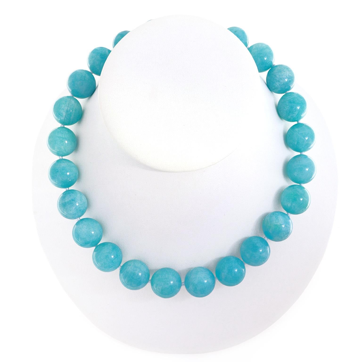 Vibrant blue green of Amazonite encompasses this necklace. Orbs of the gem, measuring 18mm, are strung together. In between a single knot of coordinating thread protects each gem. The total weight is 23 carats. An 18k yellow gold knot and toggle