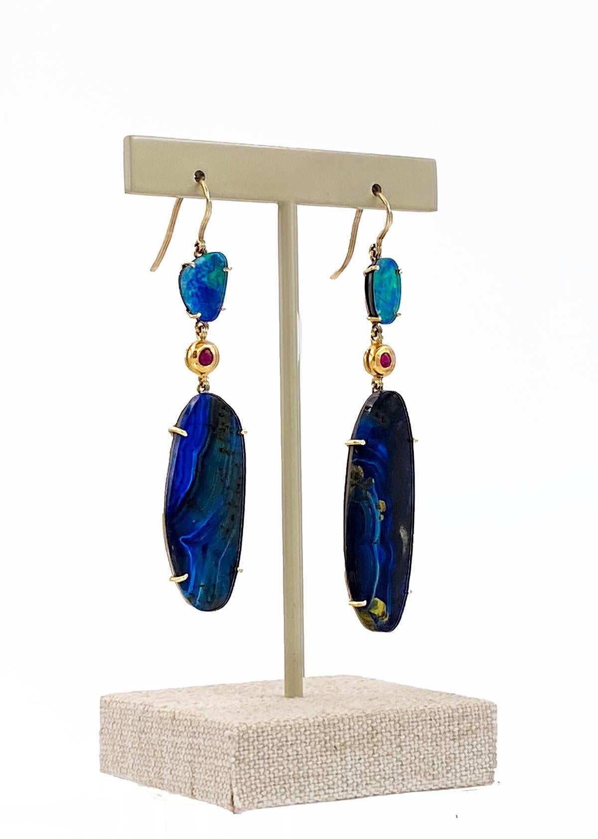 A one-of-a-kind pair of dreamy earrings by Carrie Hoffman. This vibrant pair boldly features ethereal blue-hinted natural opal and blue Amazonite, tied together with deep, bright red natural bezel-set rubies. 

The look is substantial but they are