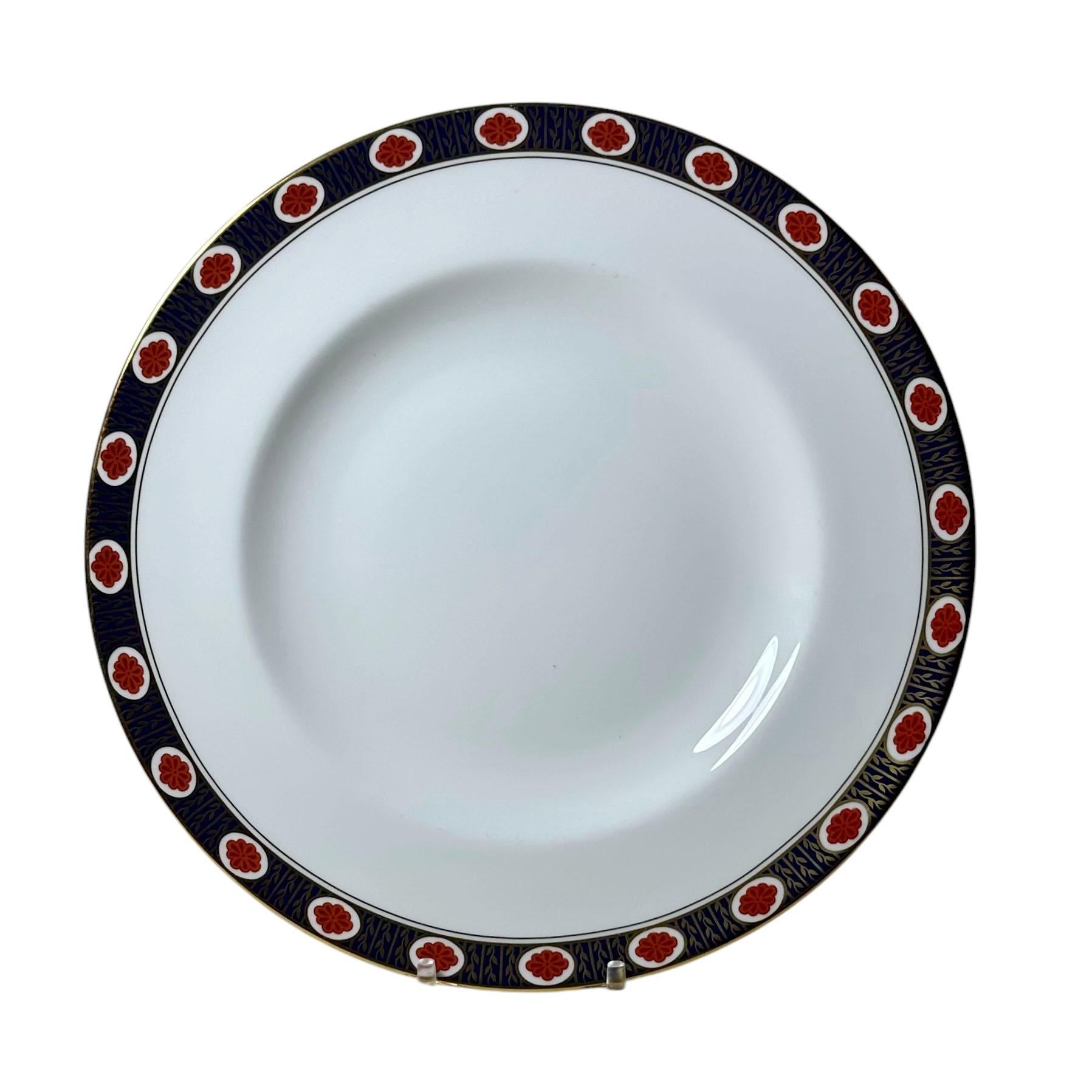 Embajador de porcelana Royal Crown Derby con hojas doradas, flores naranjas y una banda azul, juego de sesenta y tres piezas. Este juego de porcelana se dejó de fabricar entre 1987 y 1995. Royal Crown Derby, se fabrica en Derby, Inglaterra. Fundada