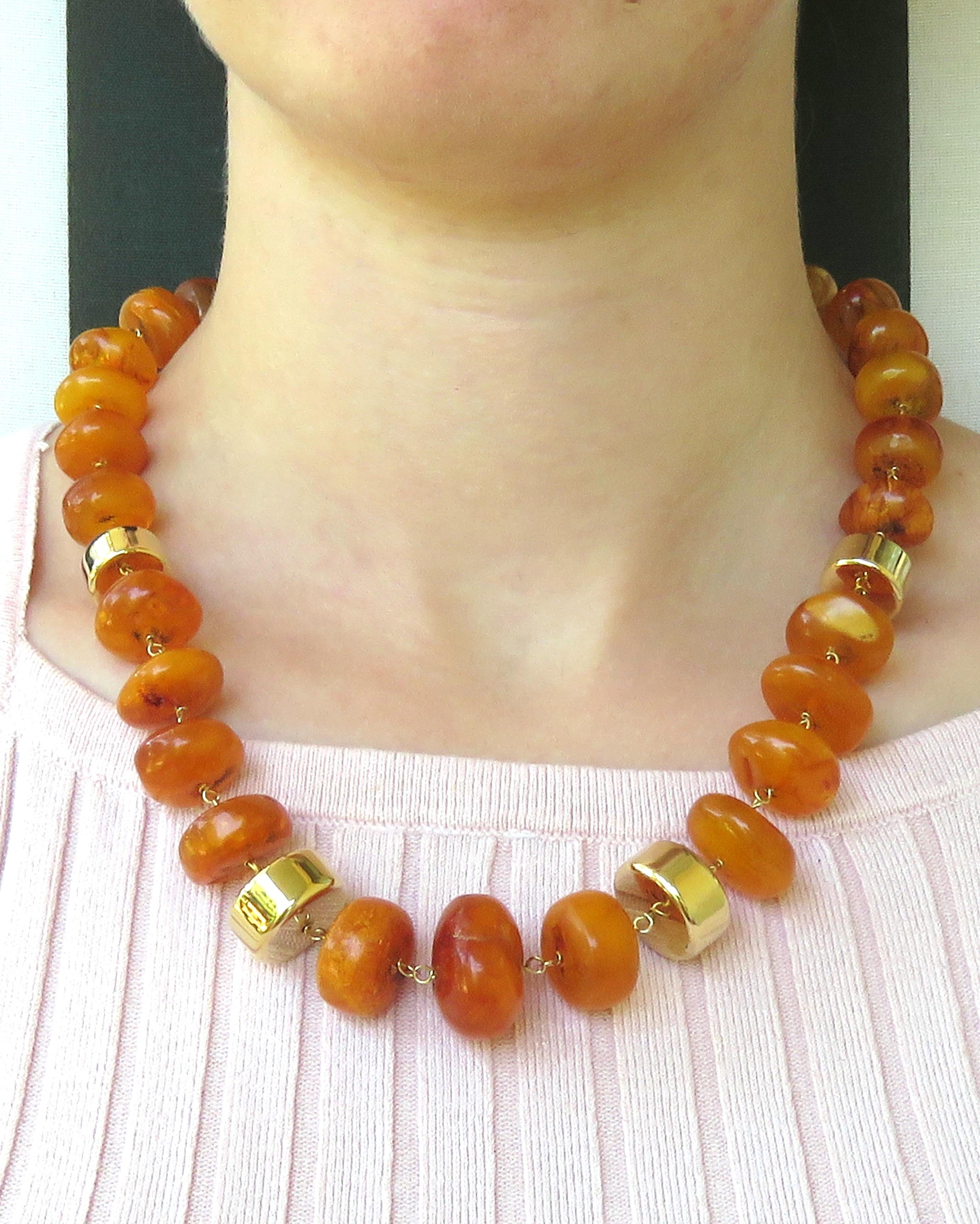 This attractive necklace of graduated Baltic honey amber beads is chained in 18 karat yellow gold with four decorative cylindrical gold beads with spring ring clasp. The total length of this princess necklace is 500 millimeters / 19.685 inches. The