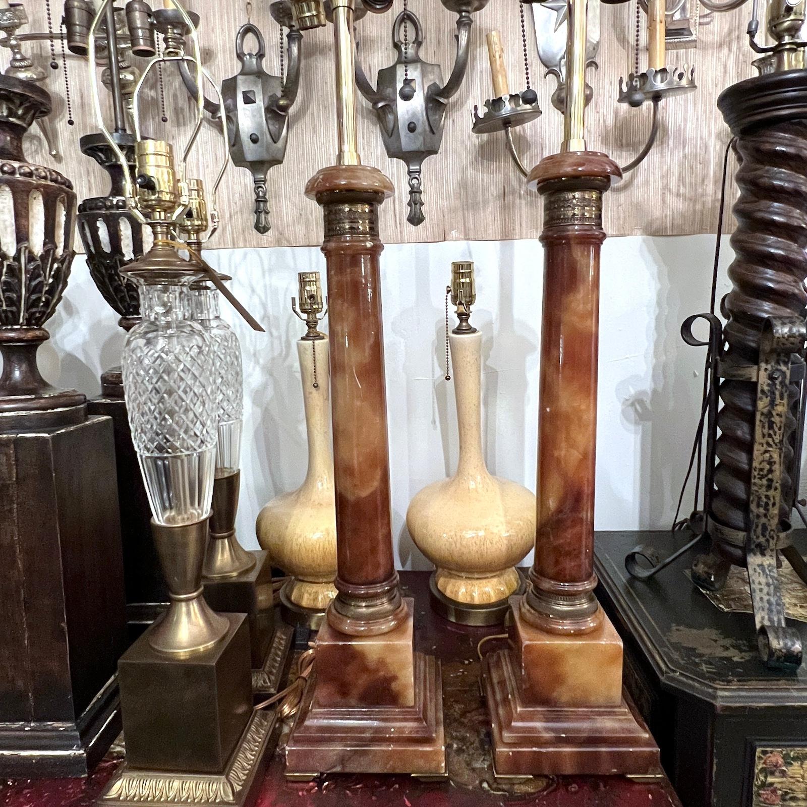 Pareja de lámparas de sobremesa de alabastro de estilo neoclásico francés de hacia 1920, con herrajes de bronce.

Medidas:
Altura del cuerpo: 23
Altura hasta el apoyo de la sombrilla: 32
Base: Cuadrada 6,5
