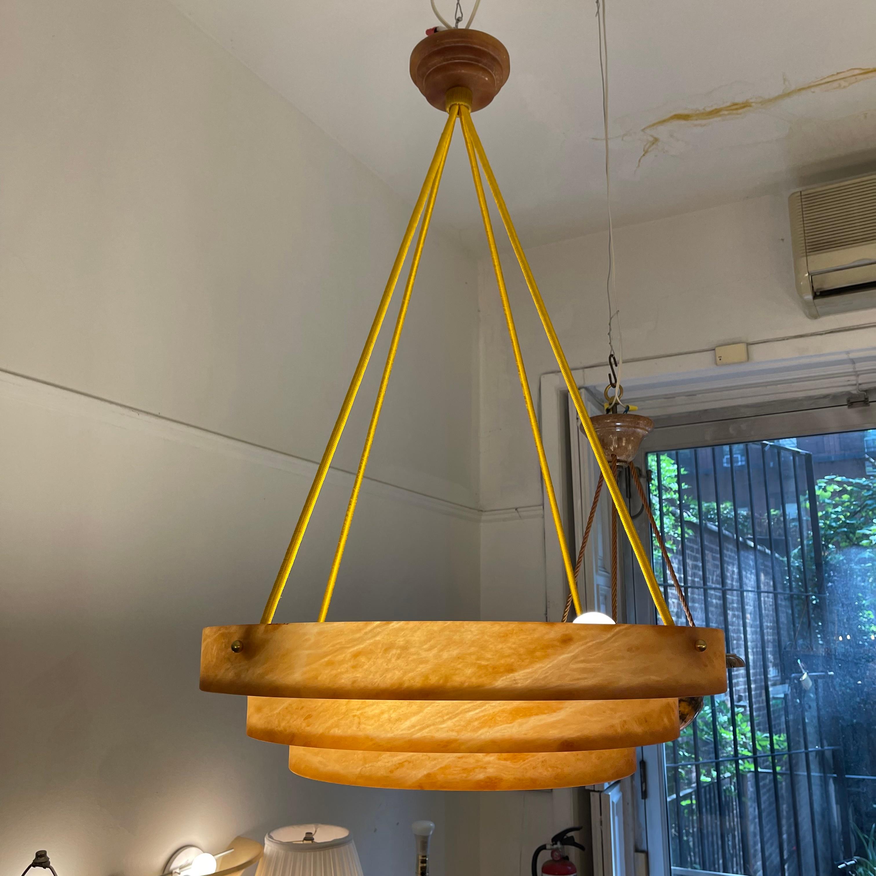 Beautiful amber stone is carved in a single piece of stone with a matching canopy. The ropes gracefully suspend the shade and hides the wiring. The ample diamter of 26