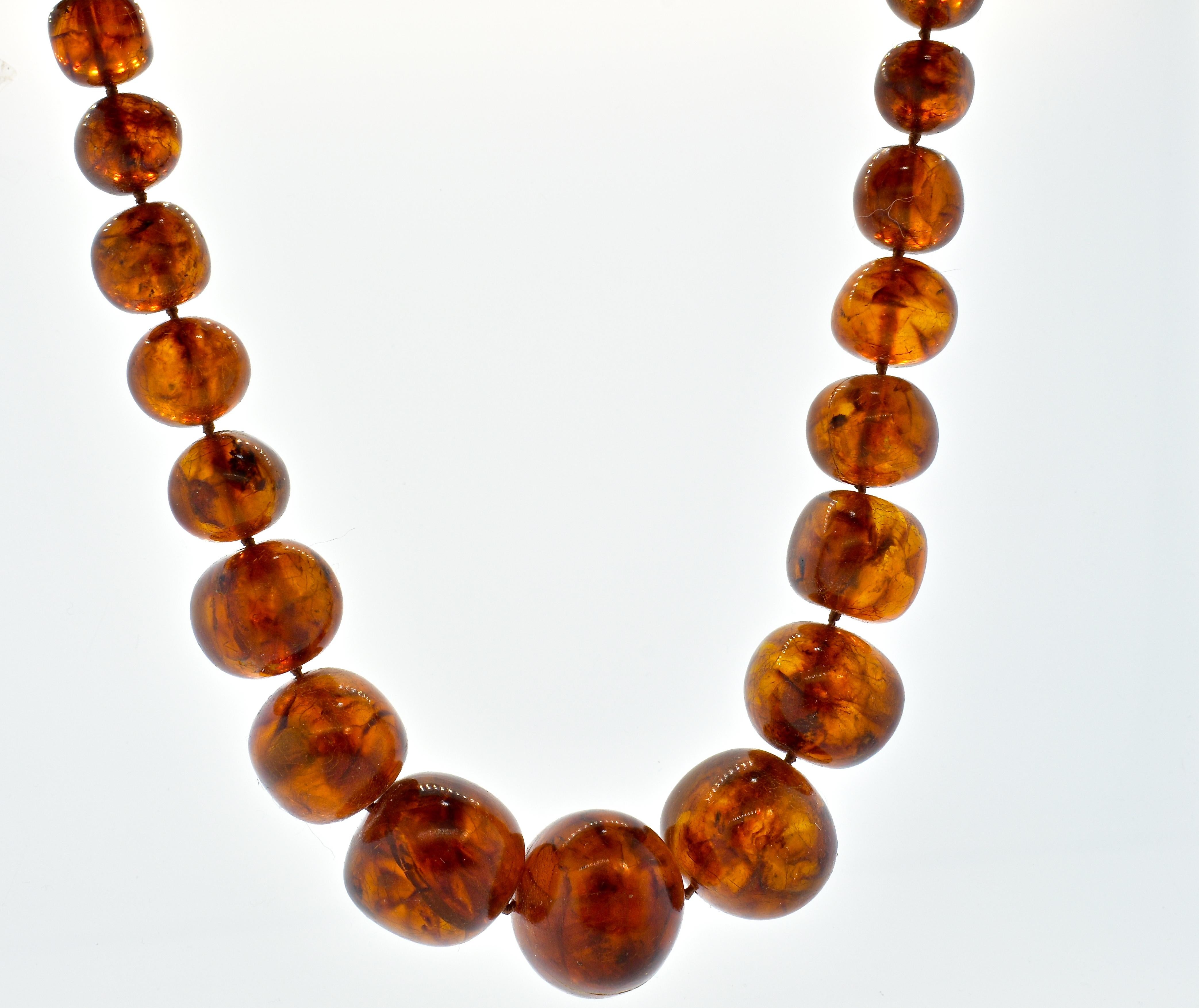 Amber, natural and very large and finished with a contemporary clasp, this early vintage natural large strand of amber beads is 26 inches in length.  The amber is a deep orange/golden color and graduates in size from 32 mm down to 10 mm.  These very