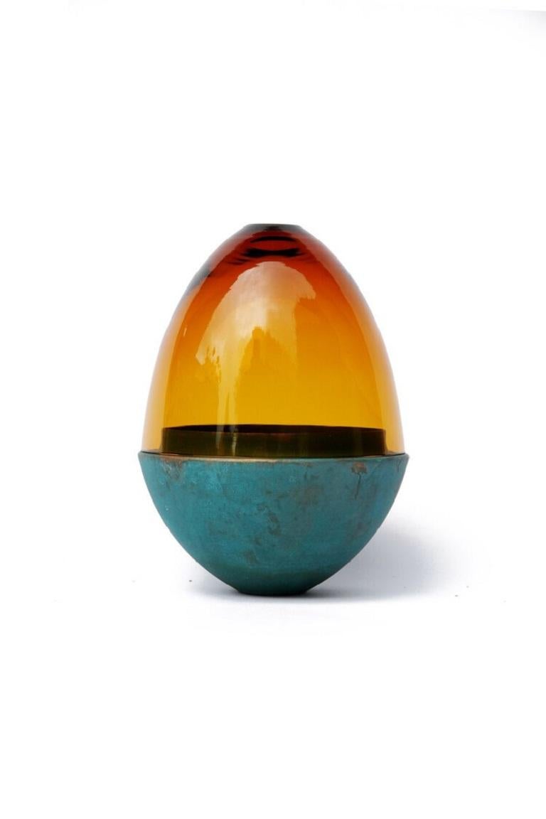 Amber and copper patina homage to faberge jewellery egg, Pia Wüstenberg.
Dimensions: D 13.5 x H 20.
Materials: glass, copper.
Available in other metals: brass, copper, brass patina, copper patina.

The contemporary reinterpretation of the