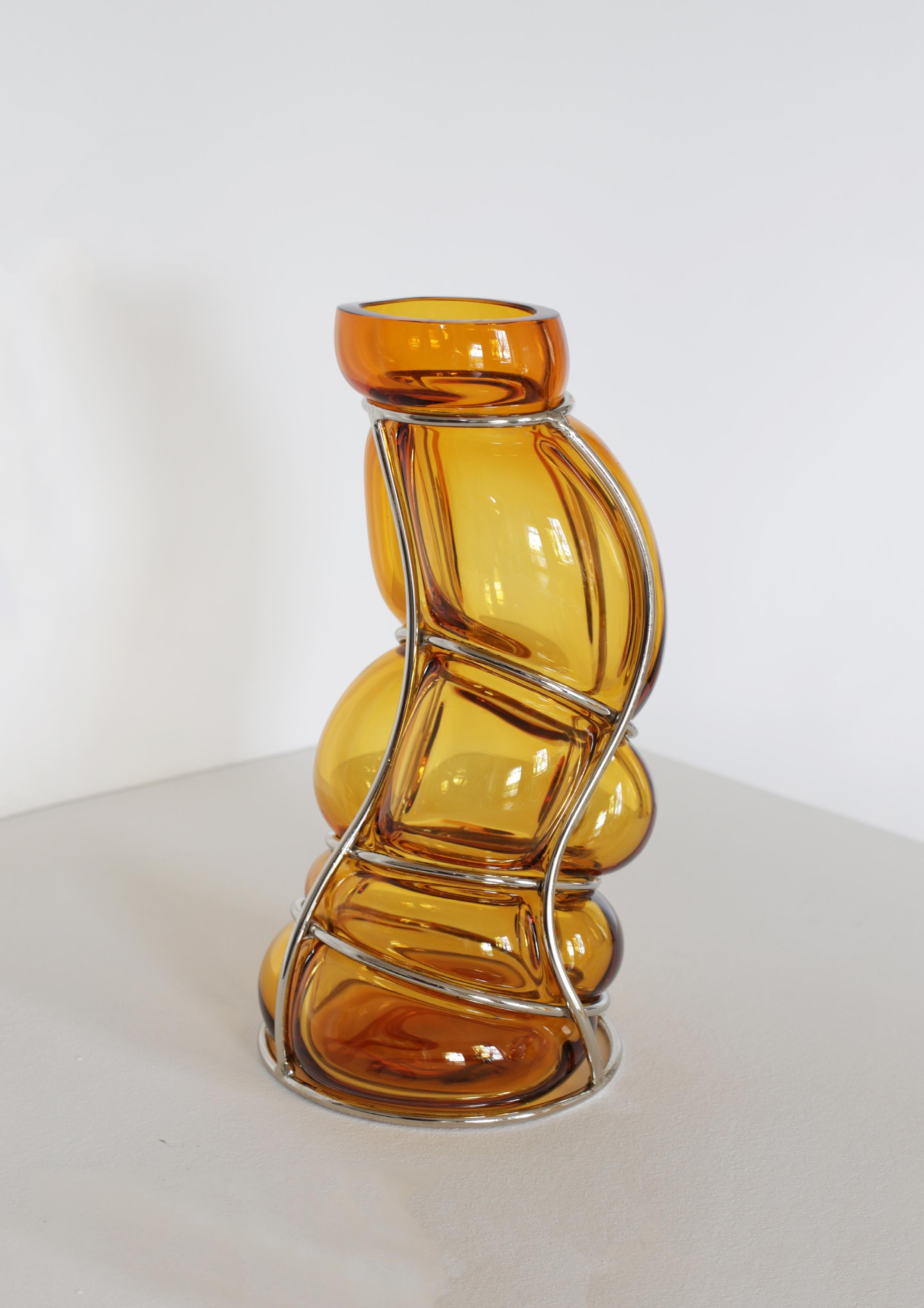 Vaso scultura Ambra Babà di Alice Crepaldi
Un pezzo unico.
Dimensioni: P 20 x L 20 x H 36 cm.
Materiali: Vetro di Murano e metallo.

Alice Crepaldi è un'artista multidisciplinare versatile che viene da Milano, Italia. I suoi sforzi artistici sono