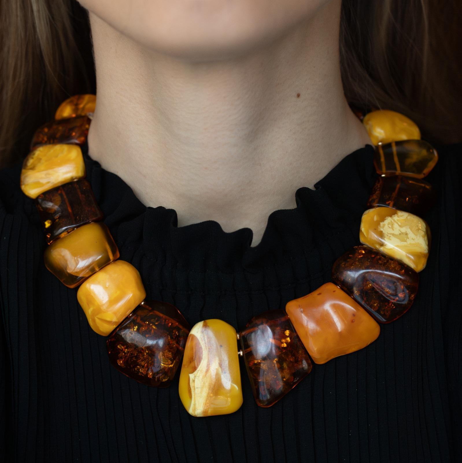 An amber bead Cleopatra style collar necklace.

This necklace is designed to sit on the collarbone, composed of alternate rough cut butterscotch amber and darker sun spangled amber beads, graduating in size ranging from the largest centre bead of