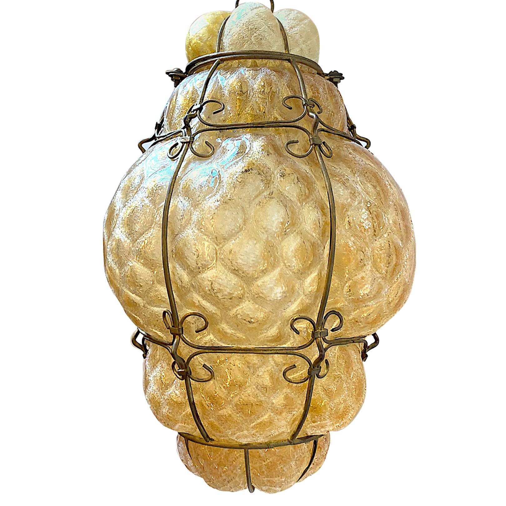 A circa 1930s Italian Amber blown glass lantern with iron work and an interior light.

Measurements:
Drop: 21