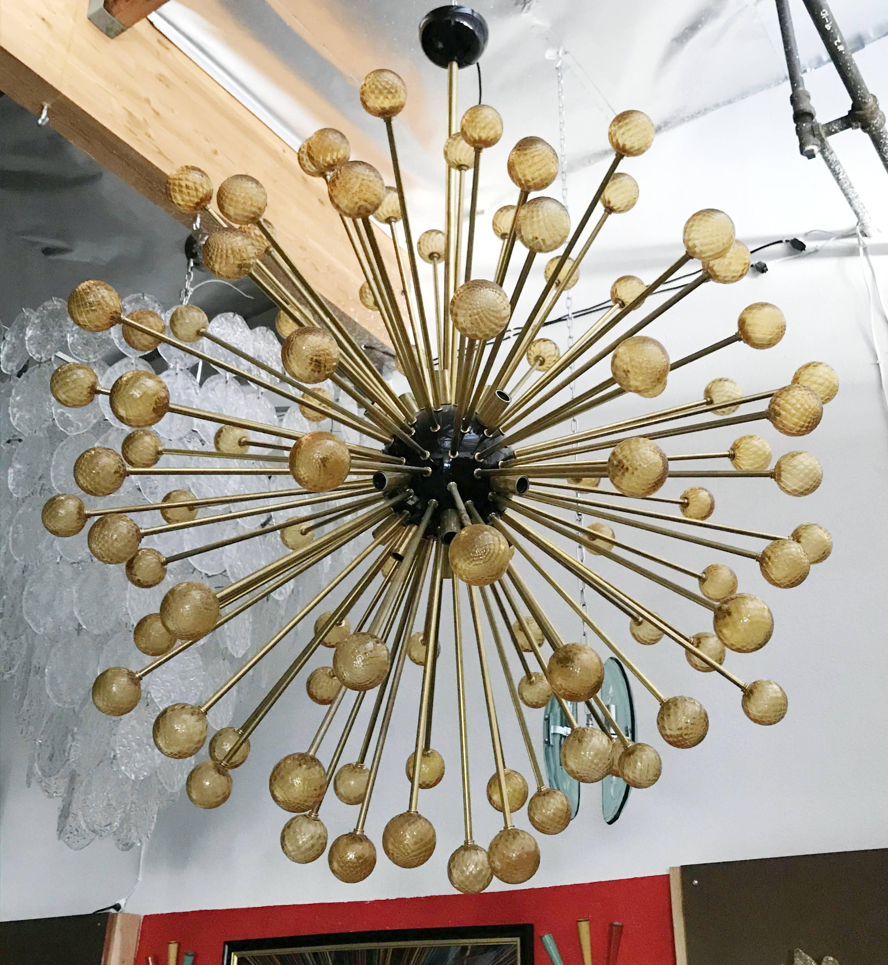 Moderna araña sputnik italiana con esferas de cristal de Murano de color ámbar texturizado, sopladas a mano, montadas en un marco de latón con el centro esmaltado en negro / Diseñada por Fabio Bergomi para Fabio Ltd. / Fabricada en Italia
16 luces /