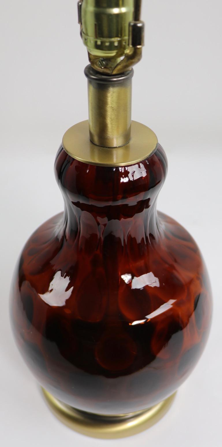 Amber, tortoiseshell color coin spot pattern art glass table lamp, this example is in very Fine original and working condition. Diameter of glass body 9 inches x height to top of glass body 14 inches x diameter of base 7 inches. Shade not included.