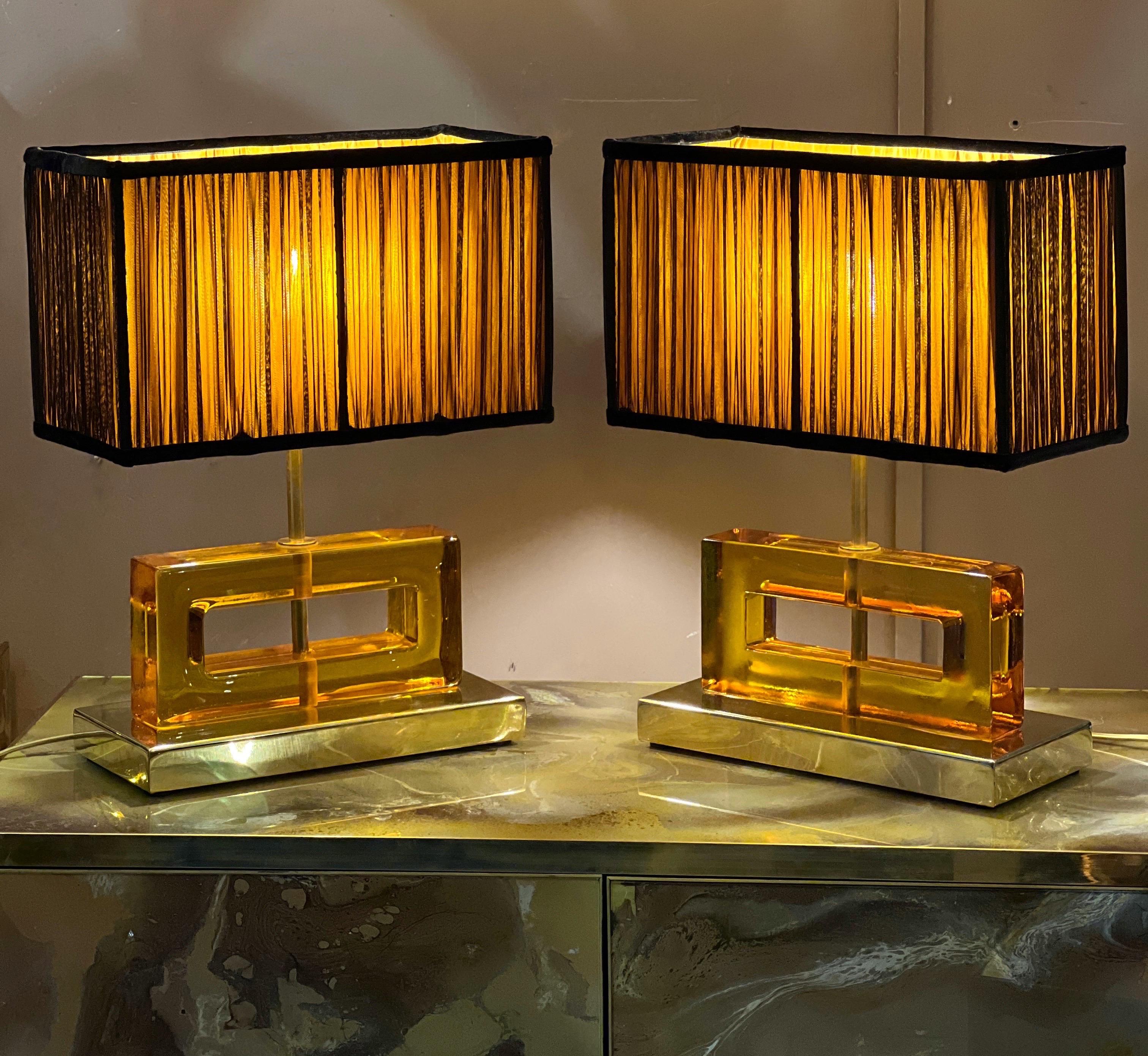 Amber color Murano glass blocks lamps with brass base and our hand sewn yellow and black lampshades.
The geometric glass blocks are solid, thick and heavy.
The double color lampshades are handmade in our internal laboratory using ruffled double