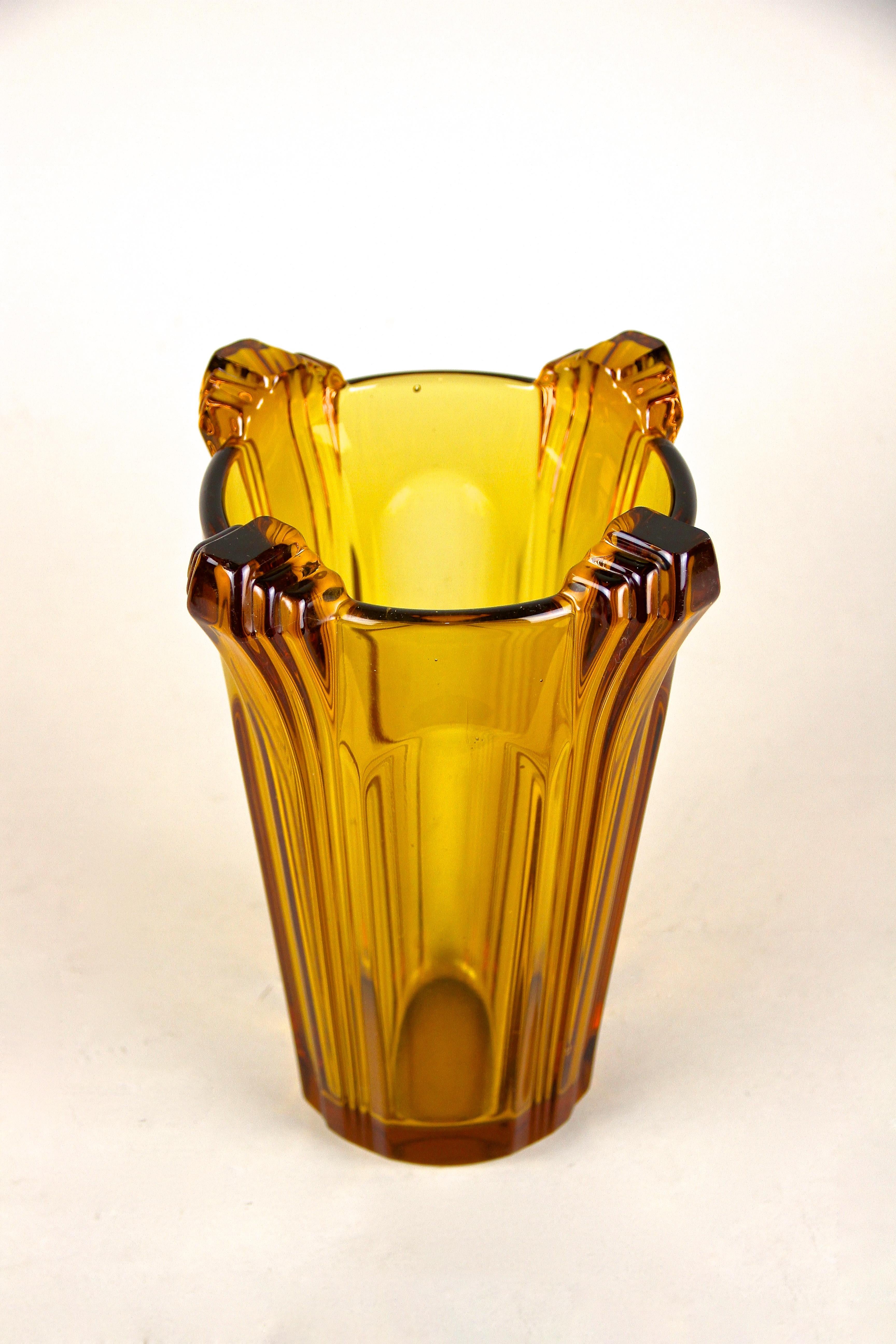 Lovely, amber colored Art Deco Glass Vase from the period circa 1920 in Austria. Showing a beautiful yellow/brown tone, this decorative glass vase impresses with its beautiful shape and shows unique design elements around the upper edge reminding us
