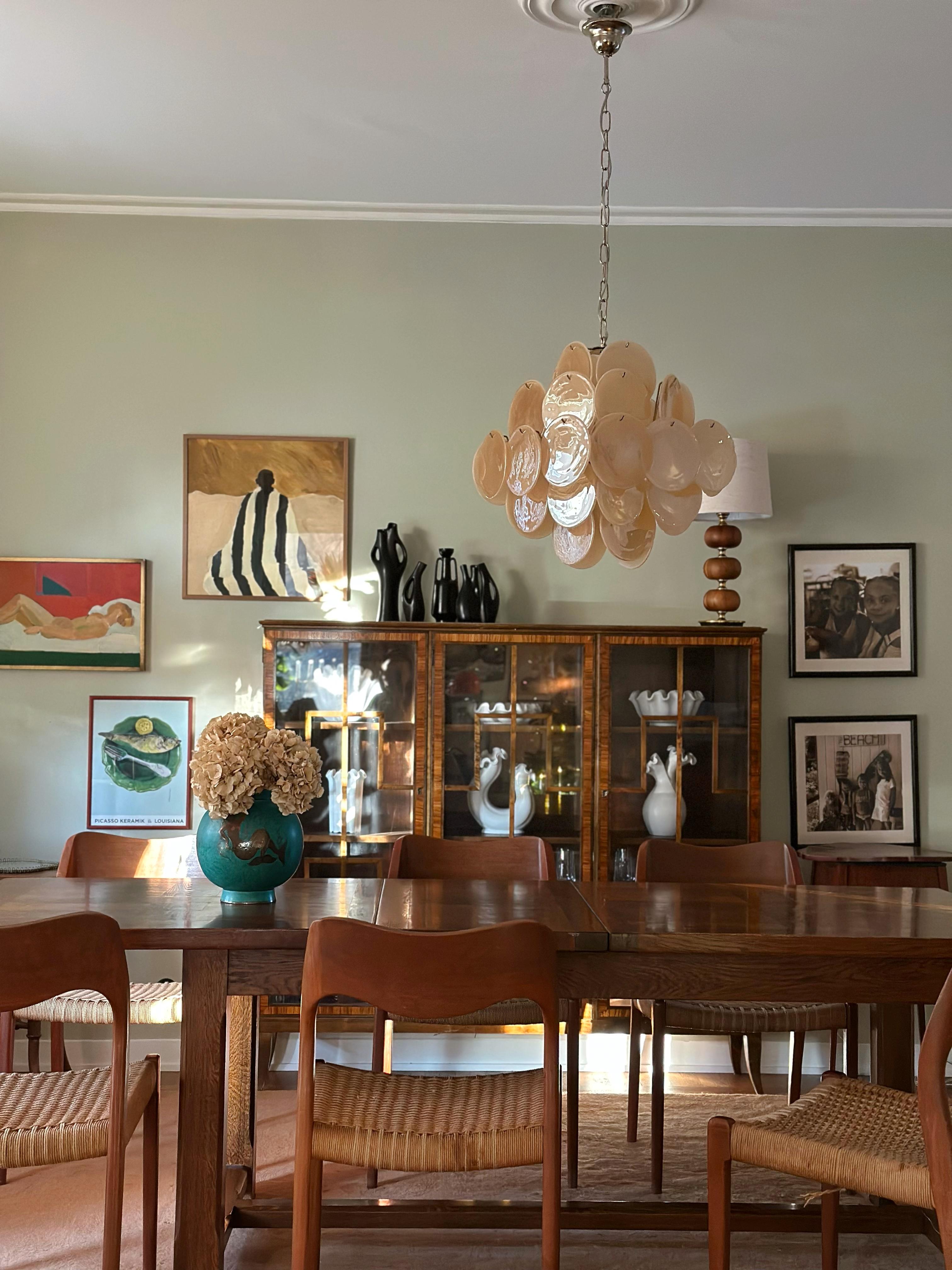 Lampadario italiano di Murano eclettico e color ambra in stile anni '70. Il lampadario ha 36 dischi di vetro in stile Vistosi con un bellissimo motivo a volute in diverse tonalità di giallo. Il diametro dei dischi di vetro è di 14-15,5 cm (fatti a