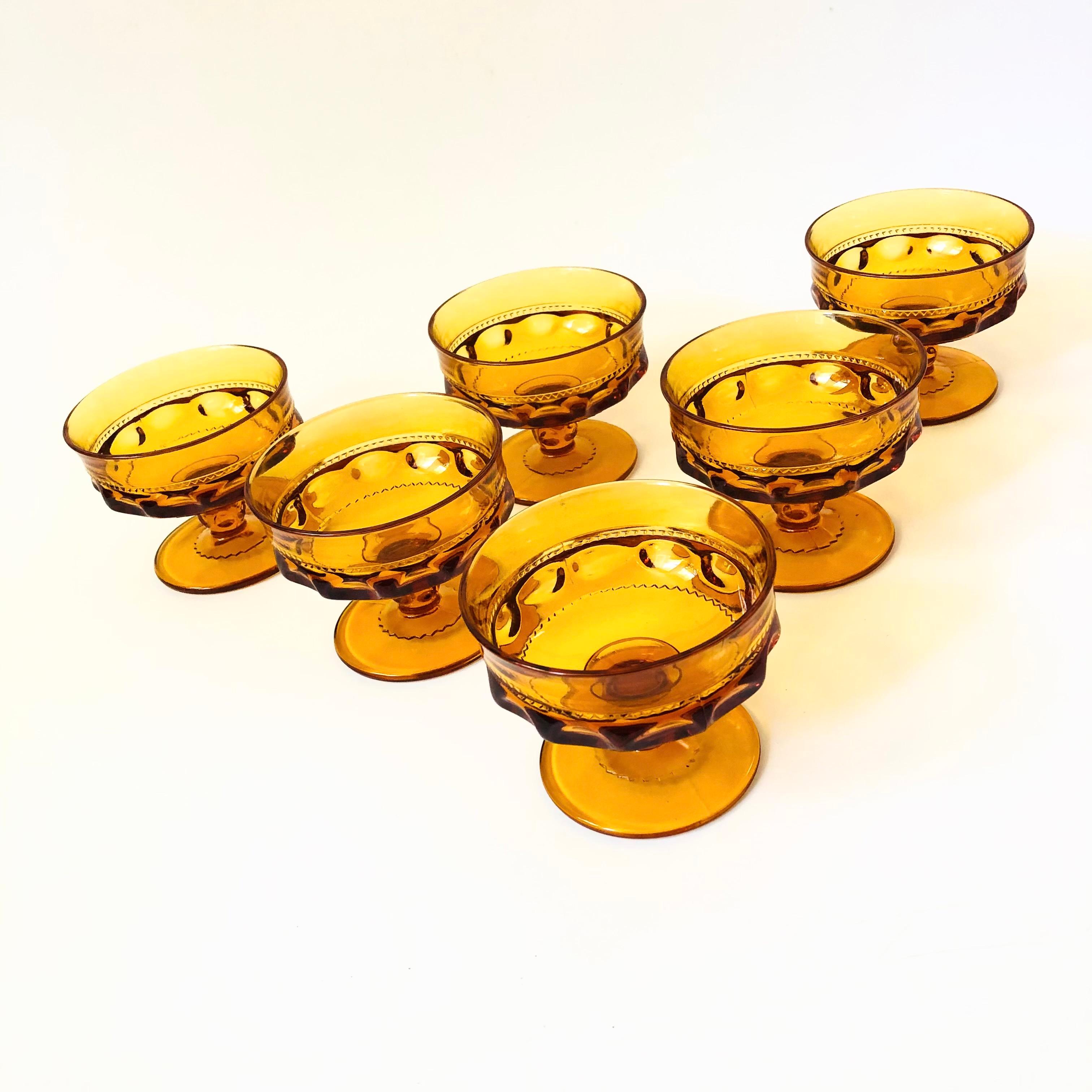 A set of 6 gorgeous coupe glasses with a lovely ornate design in amber glass. Made in the King's Crown pattern by Indiana Glass. Perfect for champagne, wine, or cocktails.

