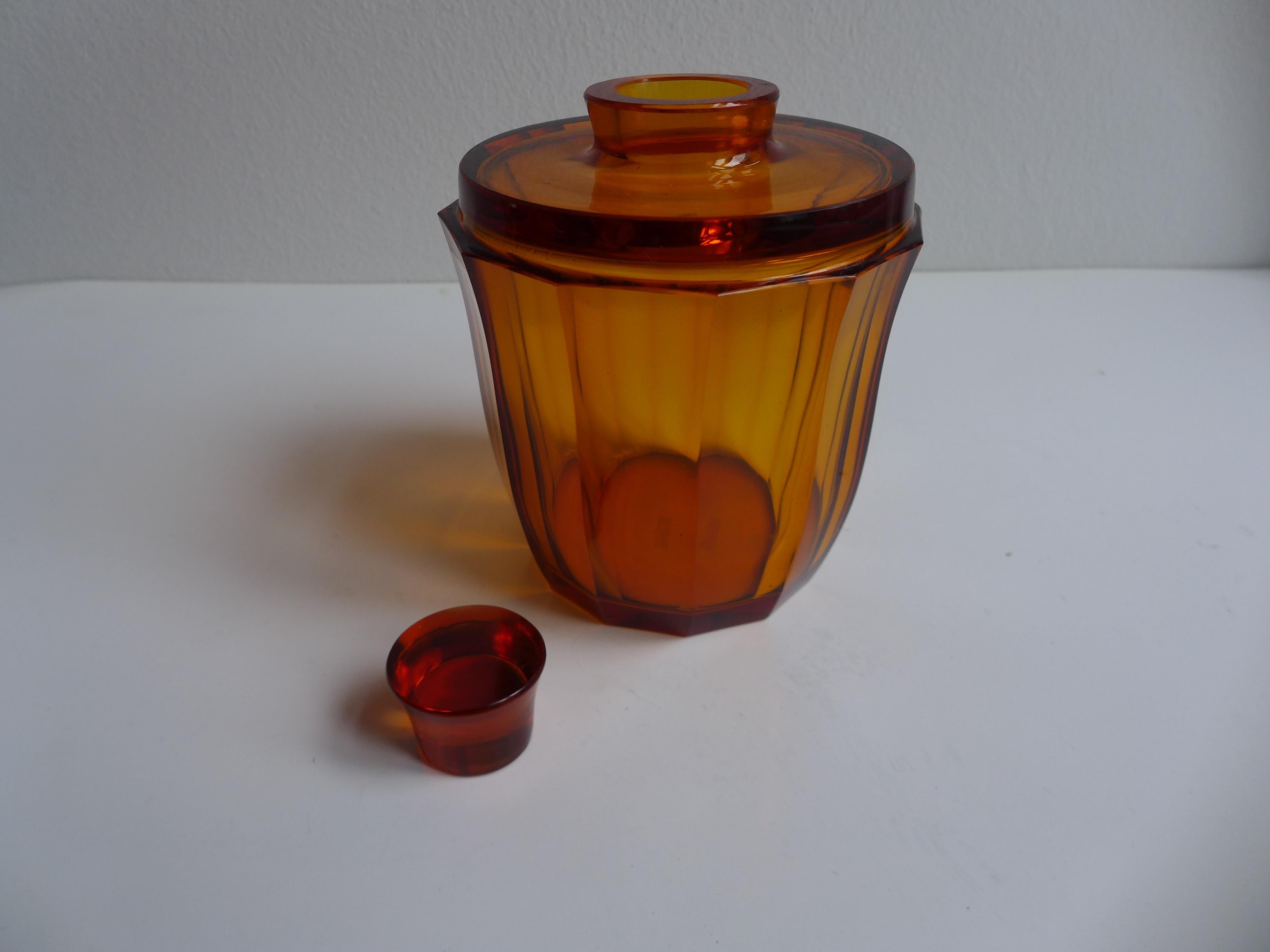 A striking whiskey decanter by Ludwig Moser, crafted in finely cut amber-colored glass. The piece reflects the refined geometric elegance associated with the Vienna Werkstätte tradition, combining precision craftsmanship with a warm, atmospheric