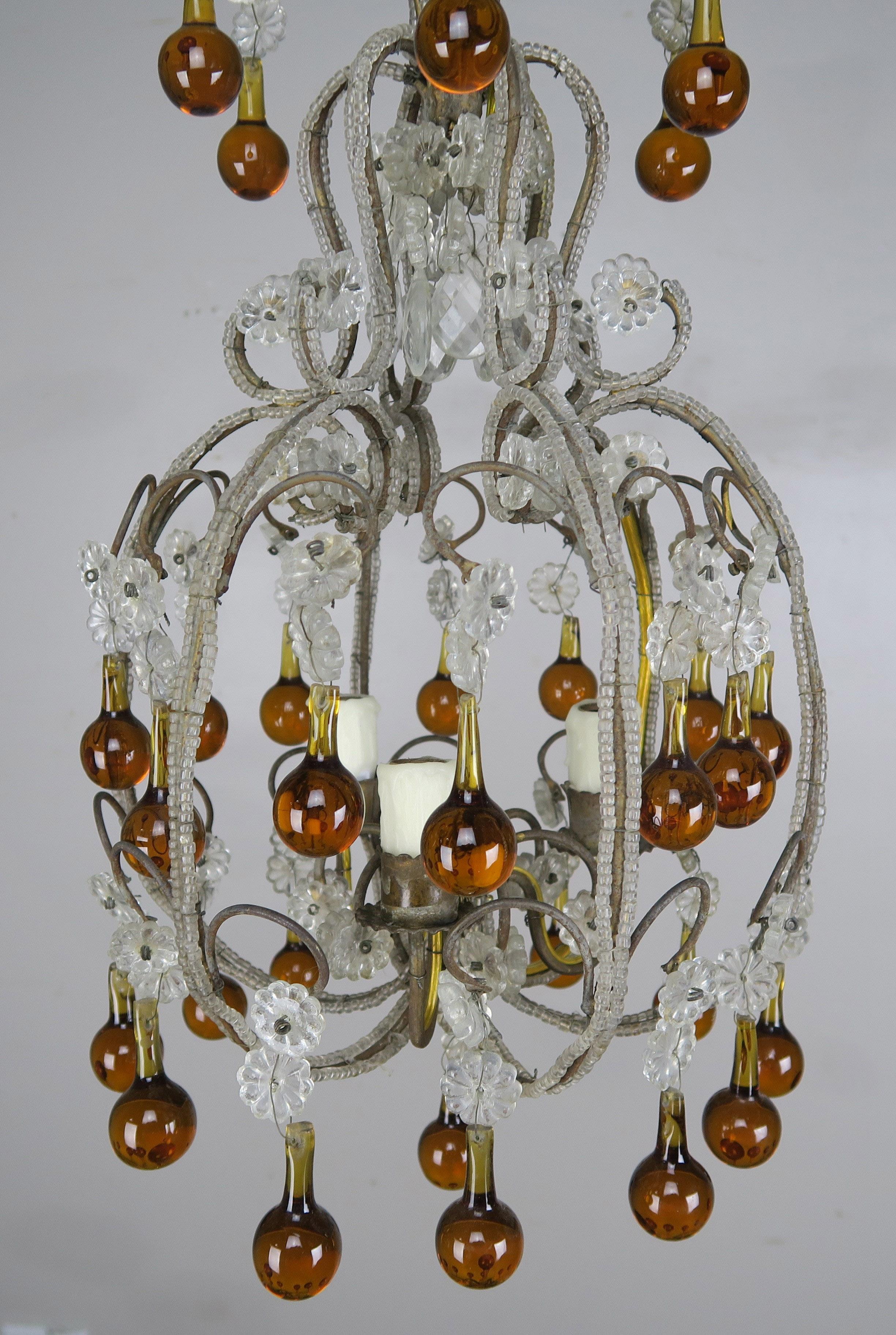 Three light crystal beaded chandelier with amber colored drops throughout. This fixture is newly wired with drip wax candle covers and is ready to install.