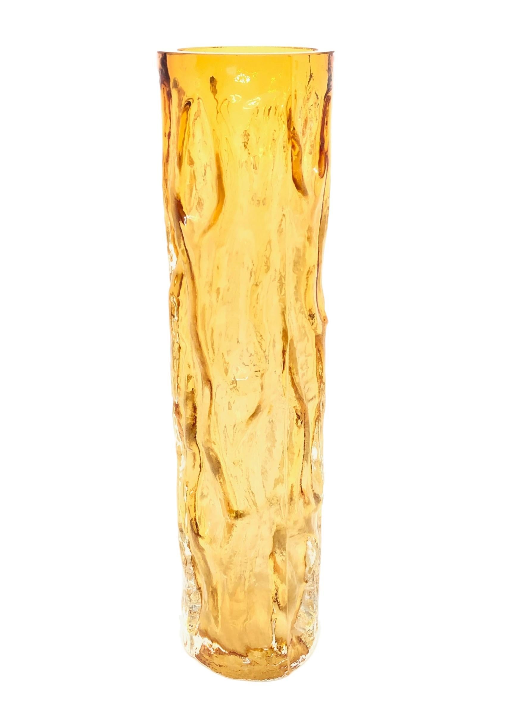 A vintage 1970s Ingrid glass vase from Germany. This hand blown vase comes in a stunning amber color and is decorated with relief wave design.