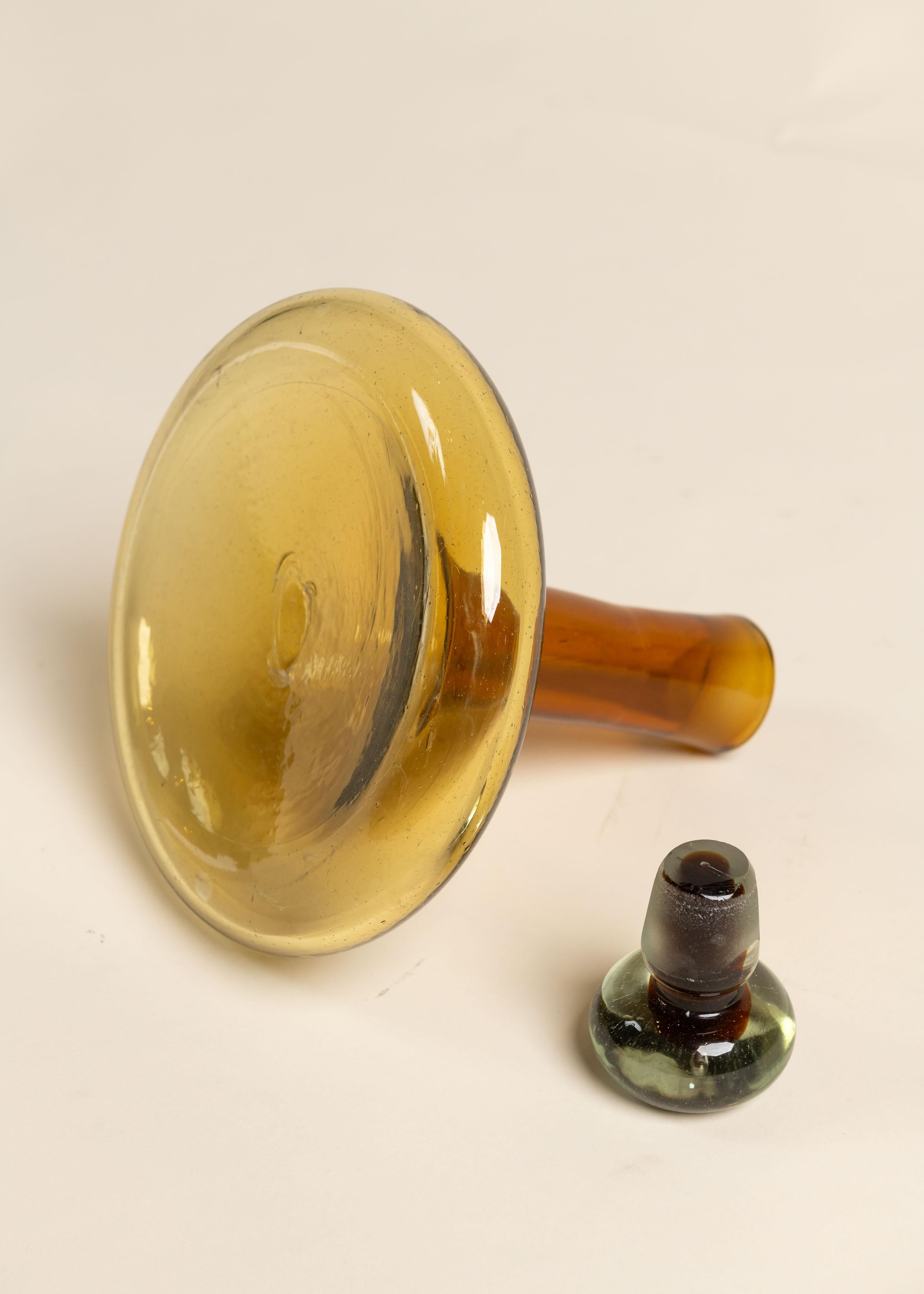 Carafe à décanter vintage en verre ambré avec son bouchon d'origine. De couleur audacieuse, c'est la pièce parfaite pour un bar ou un présentoir. Idéal comme pièce unique ou en groupe.