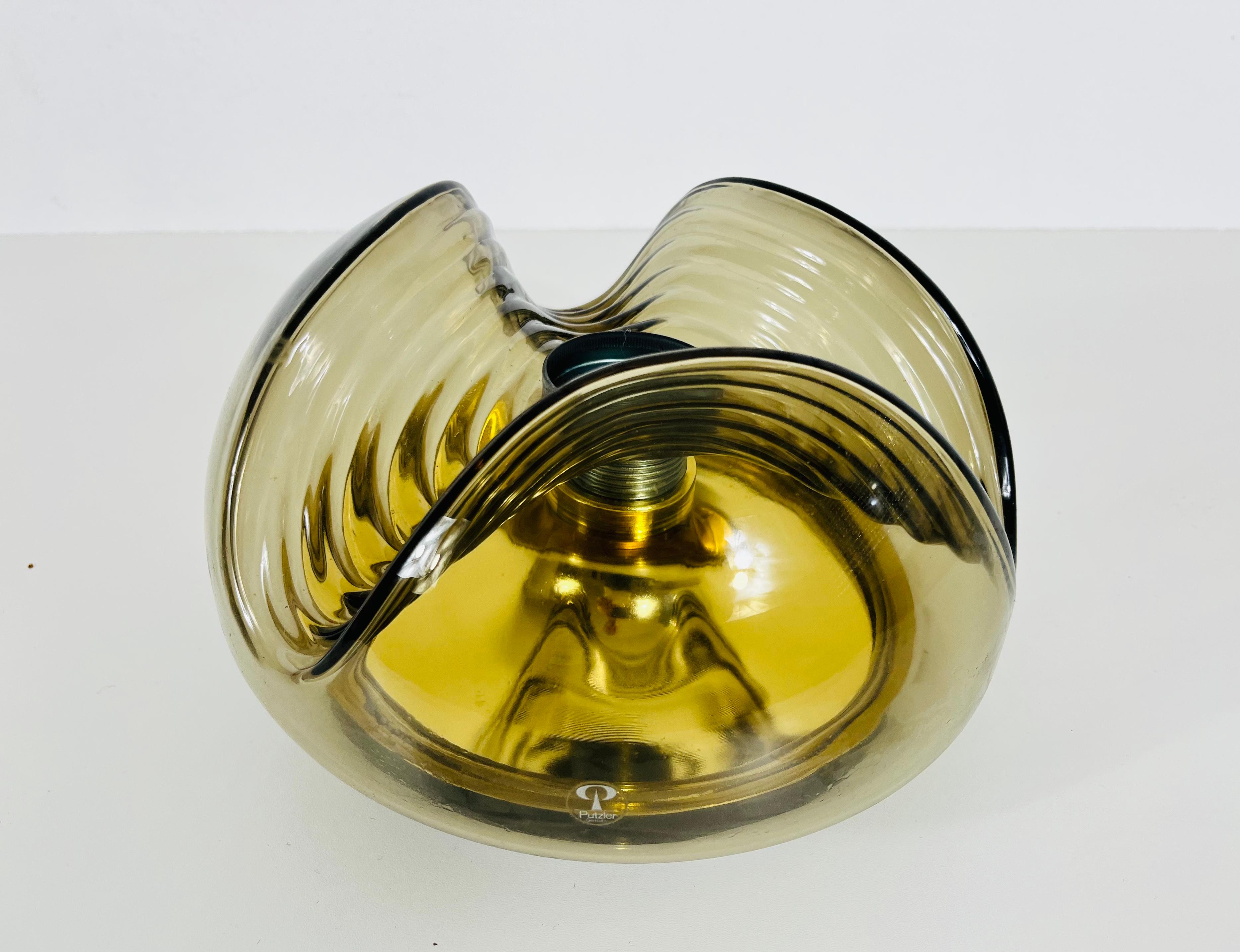 A round flush mount by Koch & Lowy for Peill and Putzler made in Germany in the 1960s. It is fascinating with its beautiful amber glass. The lamp has a Space Age design.

Very good vintage condition. Works with both 120/220V. Free worldwide