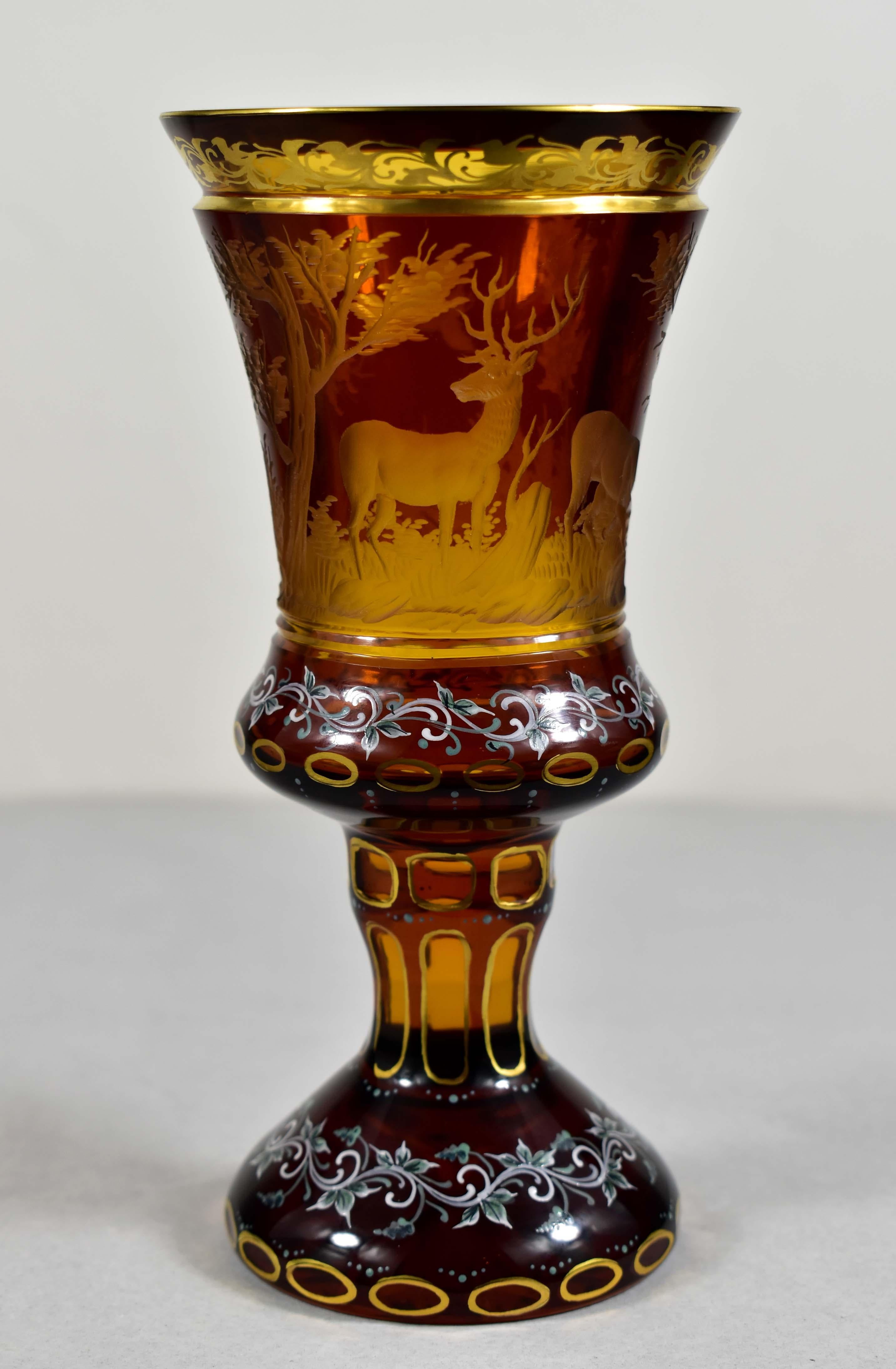 Beautiful cut , Engraved and painted amber glass goblet with yellow lazure. The engraving is a hunting motif of a deer and a doe. The deer that watches while the doe drinks from the pond. A bird flies over the pond. A very typical and popular motif