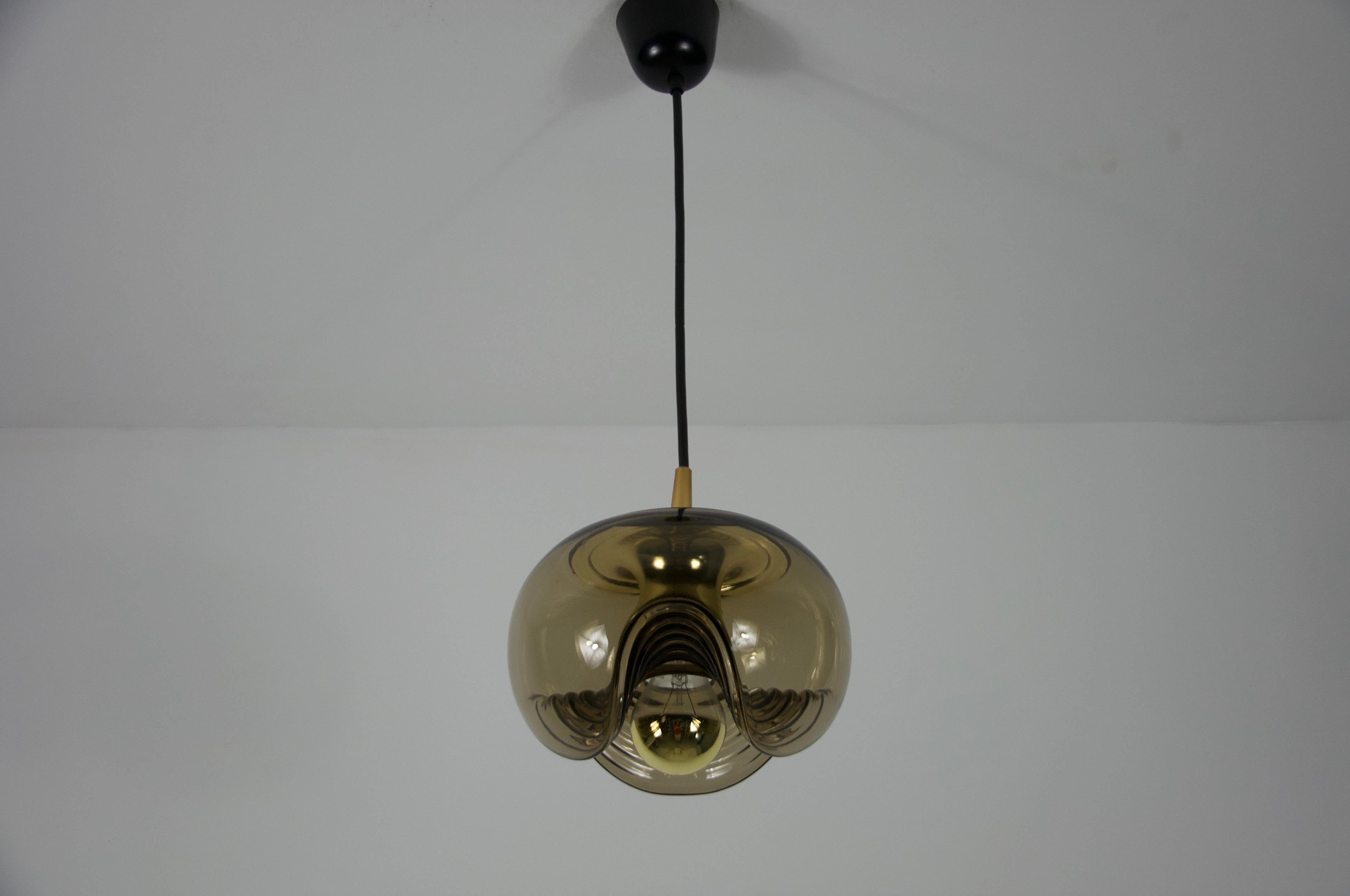 Diese Pendelleuchte von Koch & Lowy für Peill und Putzler, die in den 1960er Jahren in Deutschland hergestellt wurde, besticht durch ihr schönes Glas. Die Leuchte verkörpert das charakteristische Space-Age-Design dieser Zeit, das sich durch