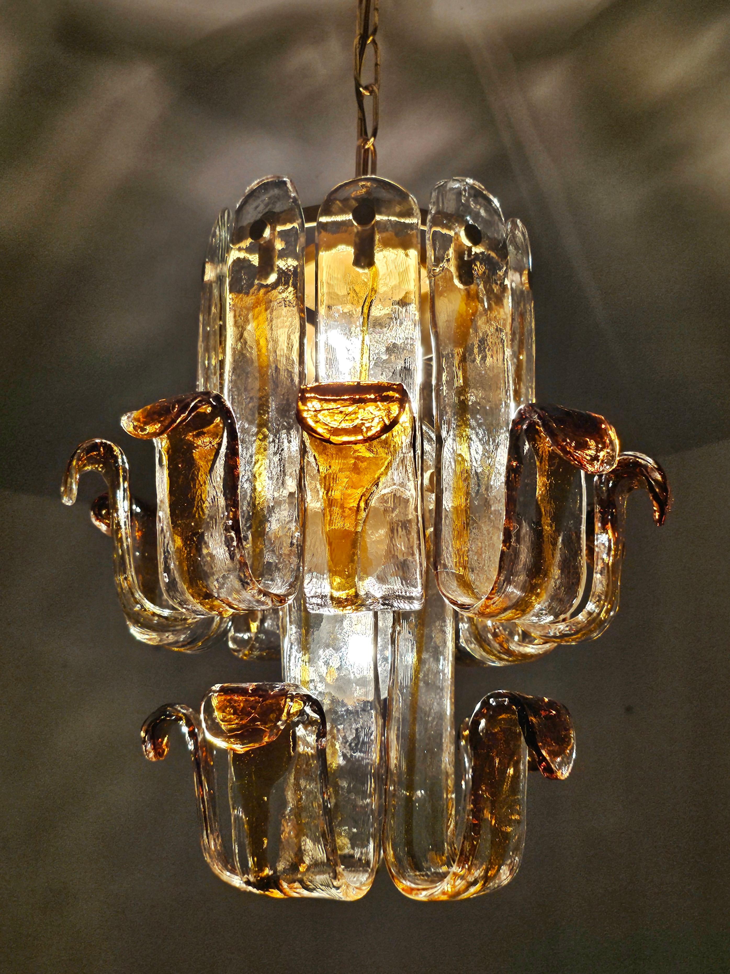 Vous trouverez dans cette liste un lustre très rare de style moderne du milieu du siècle en forme de fleur, réalisé en verre de Murano ambre et transparent. Les plaques de verre sont fixées à un support en laiton. Le lustre est conçu par Toni