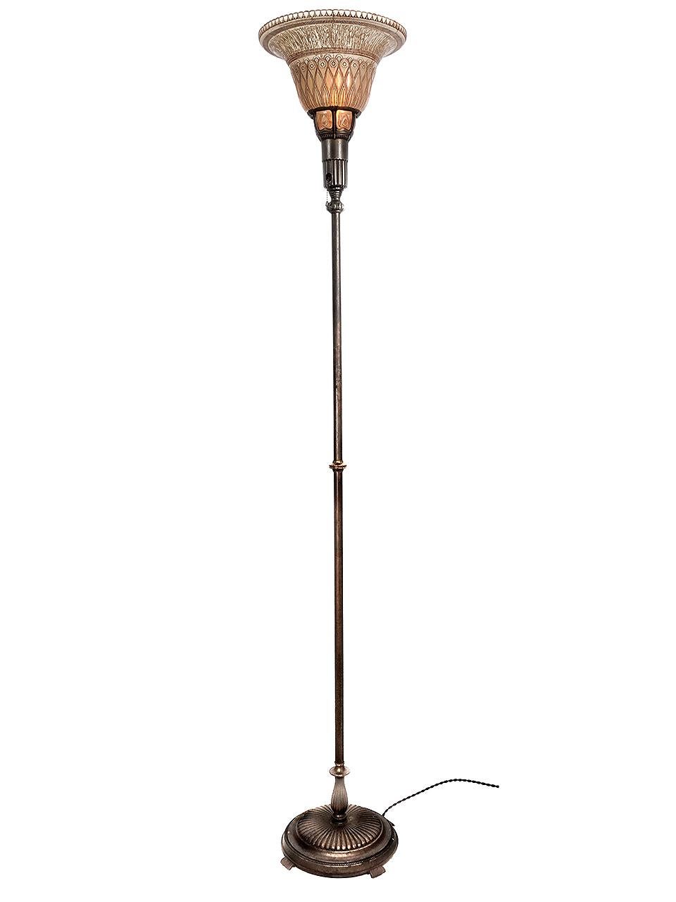 This is a rich looking and beautifully detailed Torchiere floor lamp. The glass has an etched deco floral pattern with an amber wash. The finishes are all original and show a bit of age. There is a small discolored hard to see spot on a top edge of