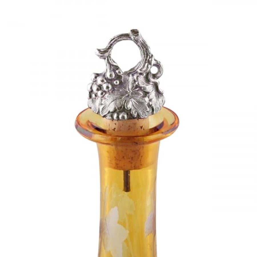 A 19th century Victorian amber glass and engraved wine decanter.

The decanter is decorated with engraved vine leaves and grapes and has a ground base.

The decanter has a Sheffield plated cork stopper in the shape of grape vines and grapes, the
