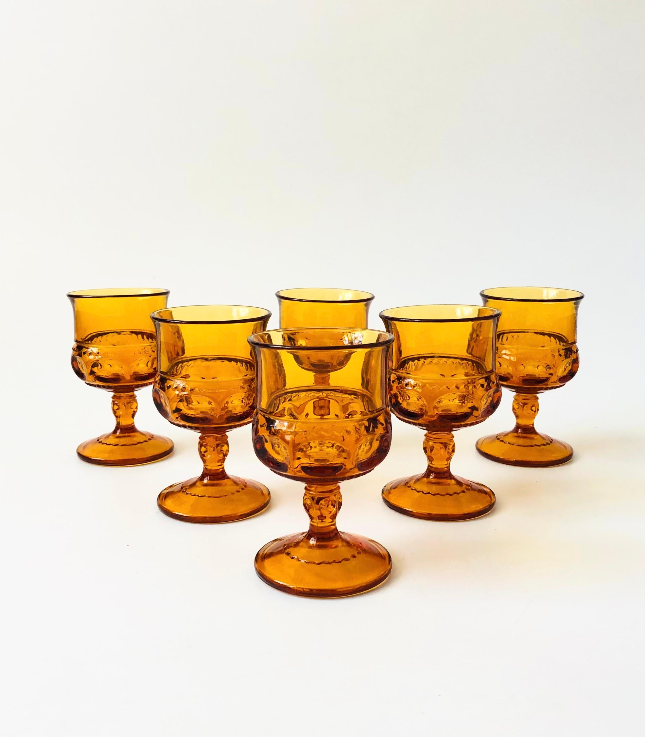 A set of 6 vintage goblets in an ornate design in amber colored glass. Made in the King's Crown pattern by Indiana Glass. Perfect for a small glass of wine or champagne.

