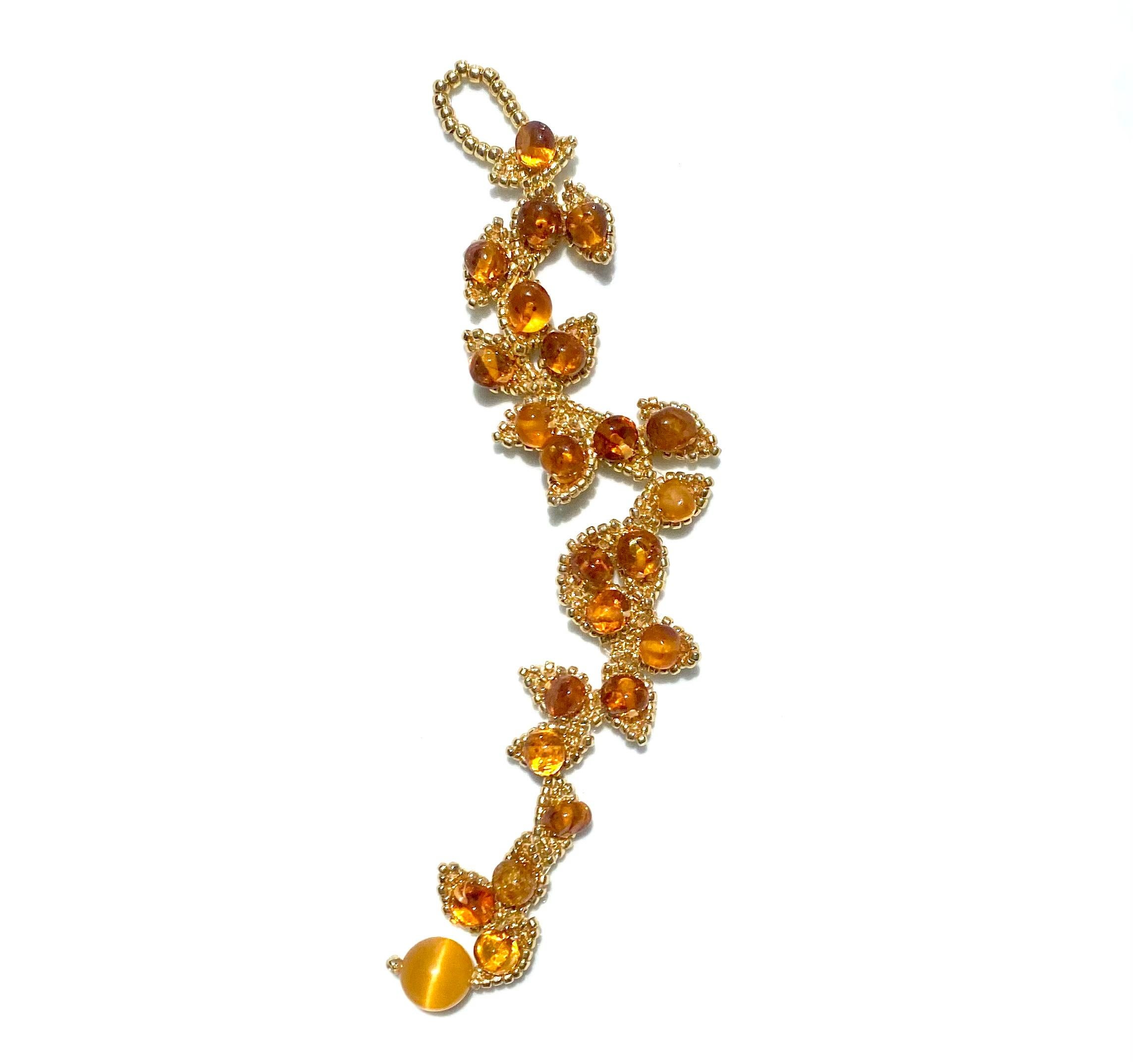 Handwoven 24k permanent gold plated Japanese glass seed beads woven in shapes of leaves, adorned with embroidered Baltic Amber oval beads. 