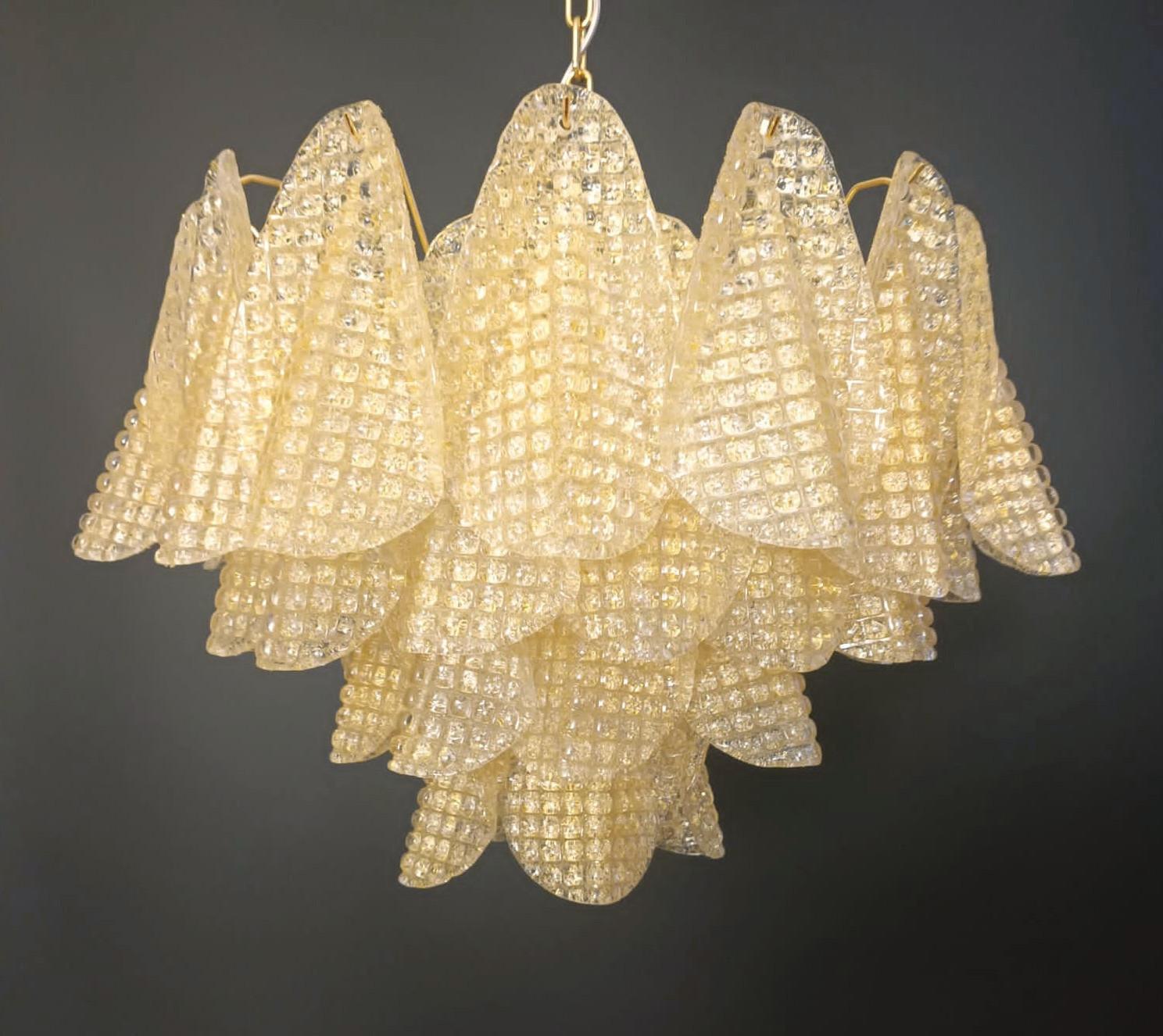 Lustre italien pétales en verre de Murano texturé clair soufflé à la main avec de la Graniglia ambre pour produire un effet texturé granuleux, monté sur une monture en métal finition or / Made in Italy
6 lampes / type E12 ou E14 / max 40W