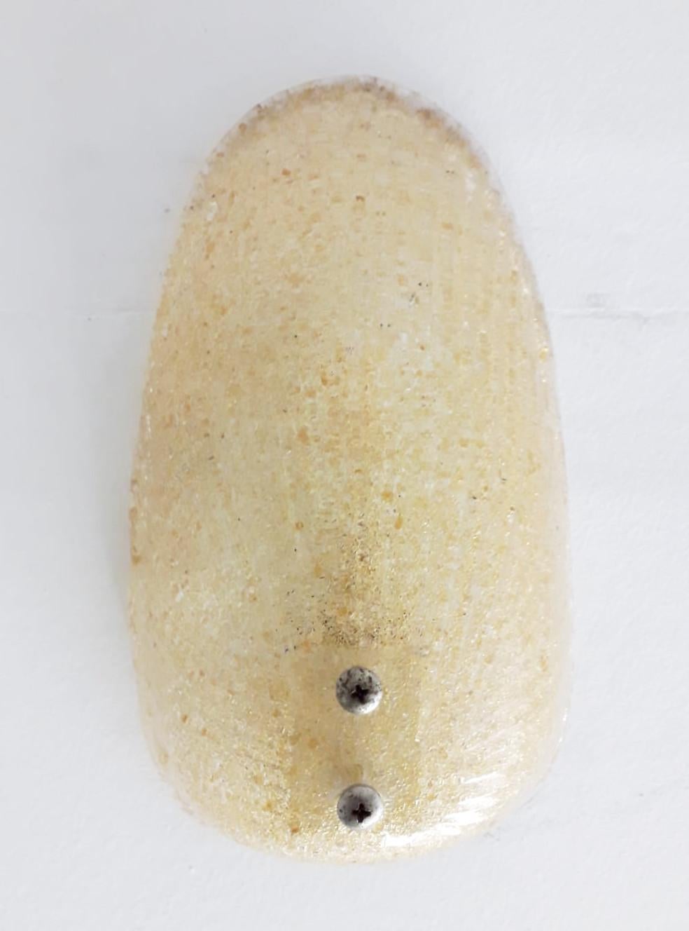 Vintage Italian wall light with oval shaped Murano glass shade hand made with amber granular effect on the glass interior using Graniglia technique, designed by Mazzega / Made in Italy circa 1960s
1 light / E12 or E14 type / max 40W
Measures: Height