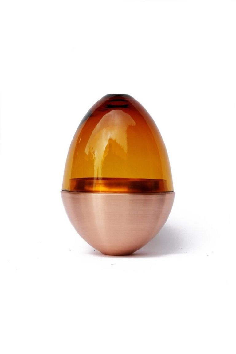 Amber Homage to Faberge jewellery egg, Pia Wüstenberg.
Dimensions: D 13.5 x H 20.
Materials: glass, metal.
Available in other metals: brass, copper, brass patina, copper patina.

The contemporary reinterpretation of the famous jewellery