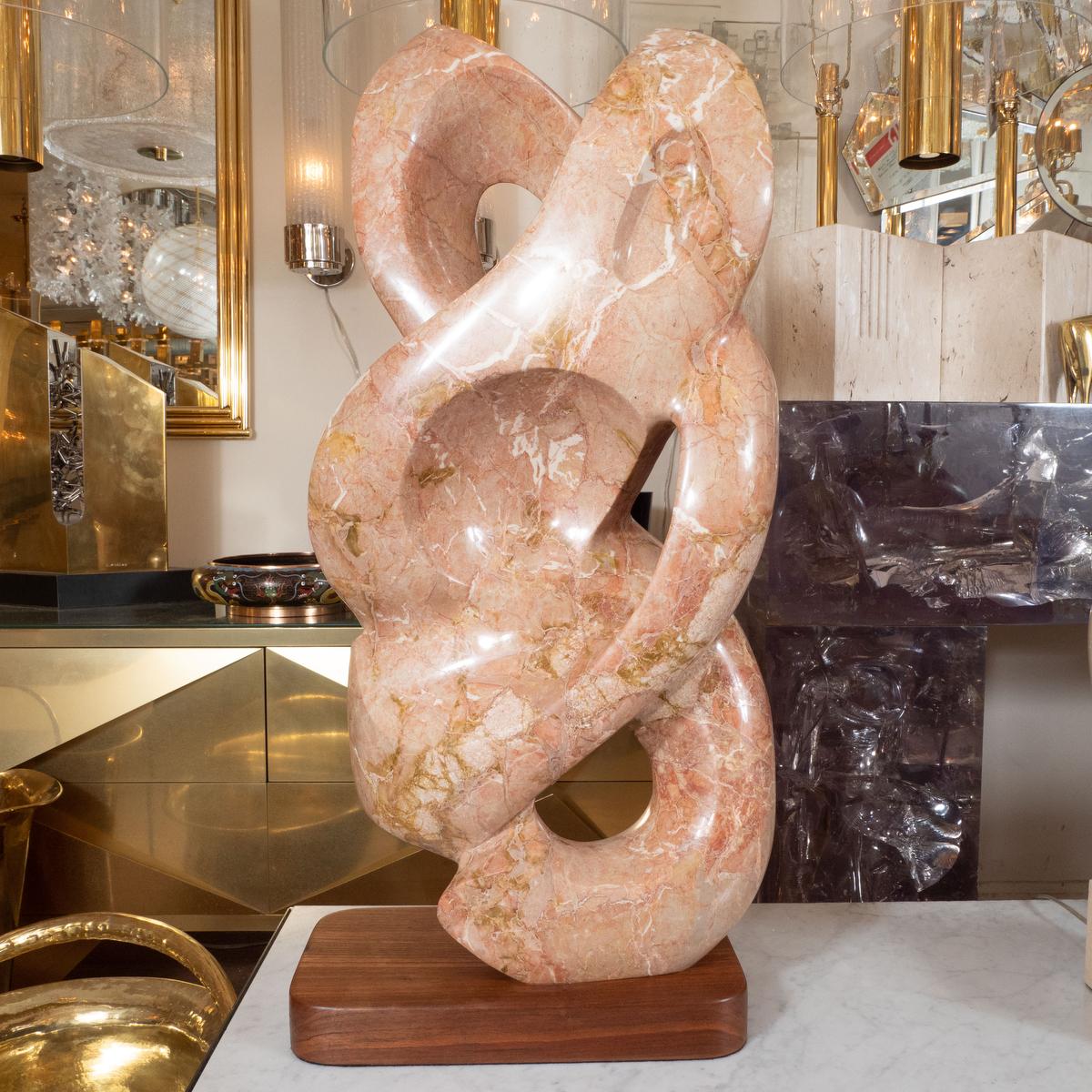 Amber marble serpentine abstract sculpture with wood base.