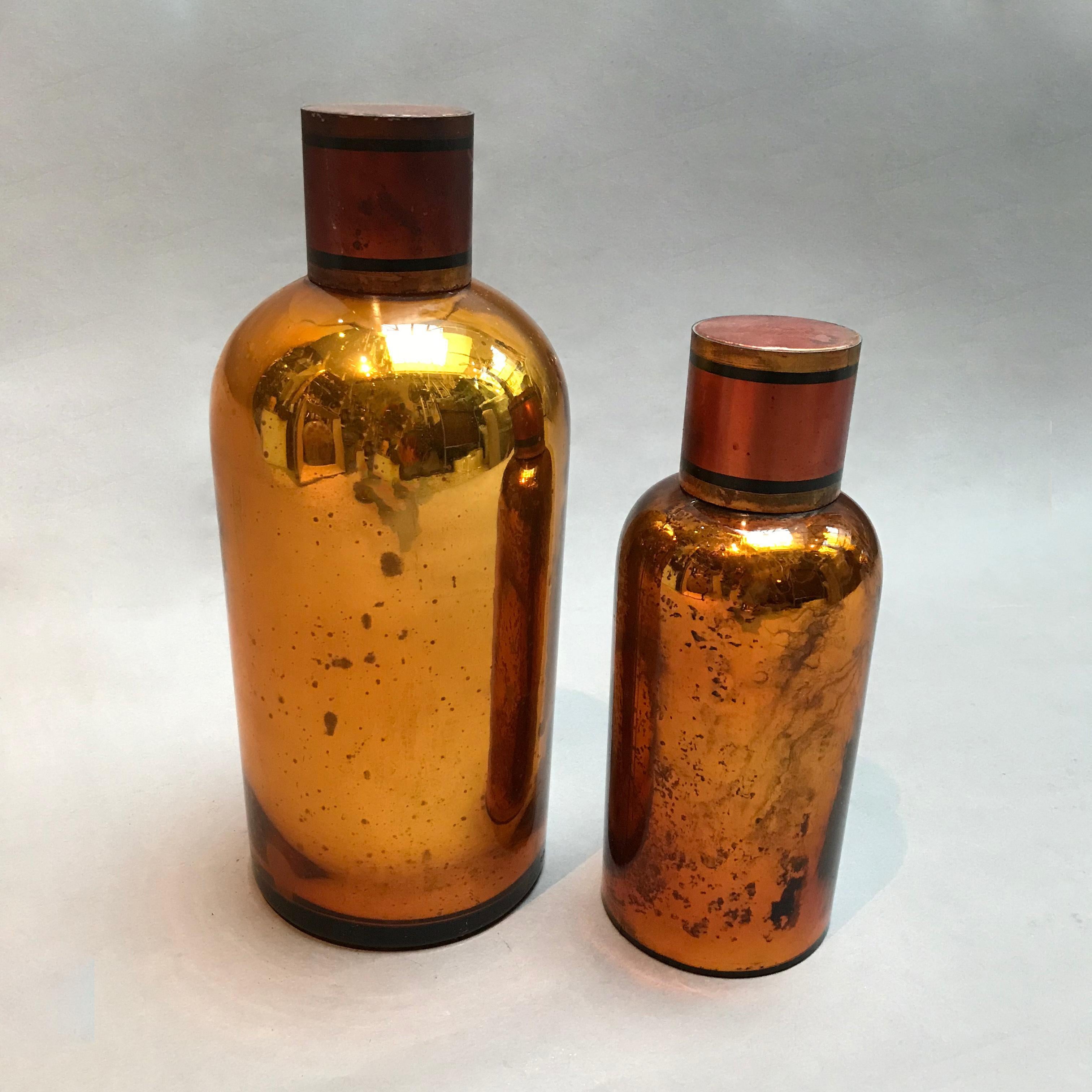Pair of early 20th century, amber mercury glass, apothecary jars with tin lids.
Large jar measures 4.75 inches diameter x 12 inches height, small jar measures 3.5 inches diameter x 9.5 inches height.