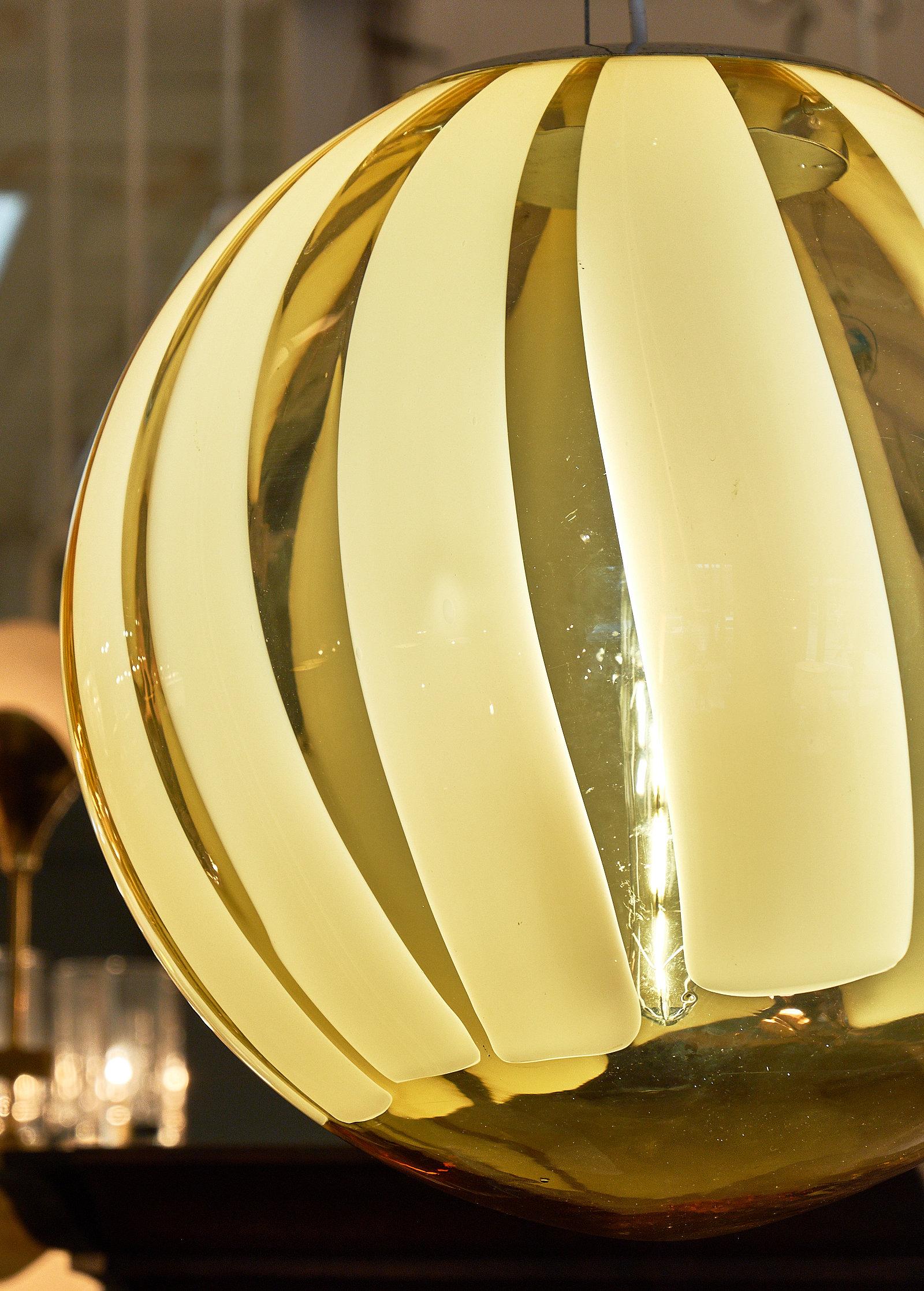 Hand blown Murano glass amber sphere chandelier. A spectacular globe pendant featuring the “incamisciato