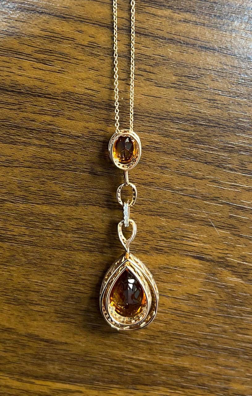 This stunning pendant necklace features a captivating design with a vibrant orange citrine gemstones centerpiece. The pendant showcases a teardrop-shaped gem, elegantly framed by a halo of sparkling diamonds, suspended from a delicate chain. Above,