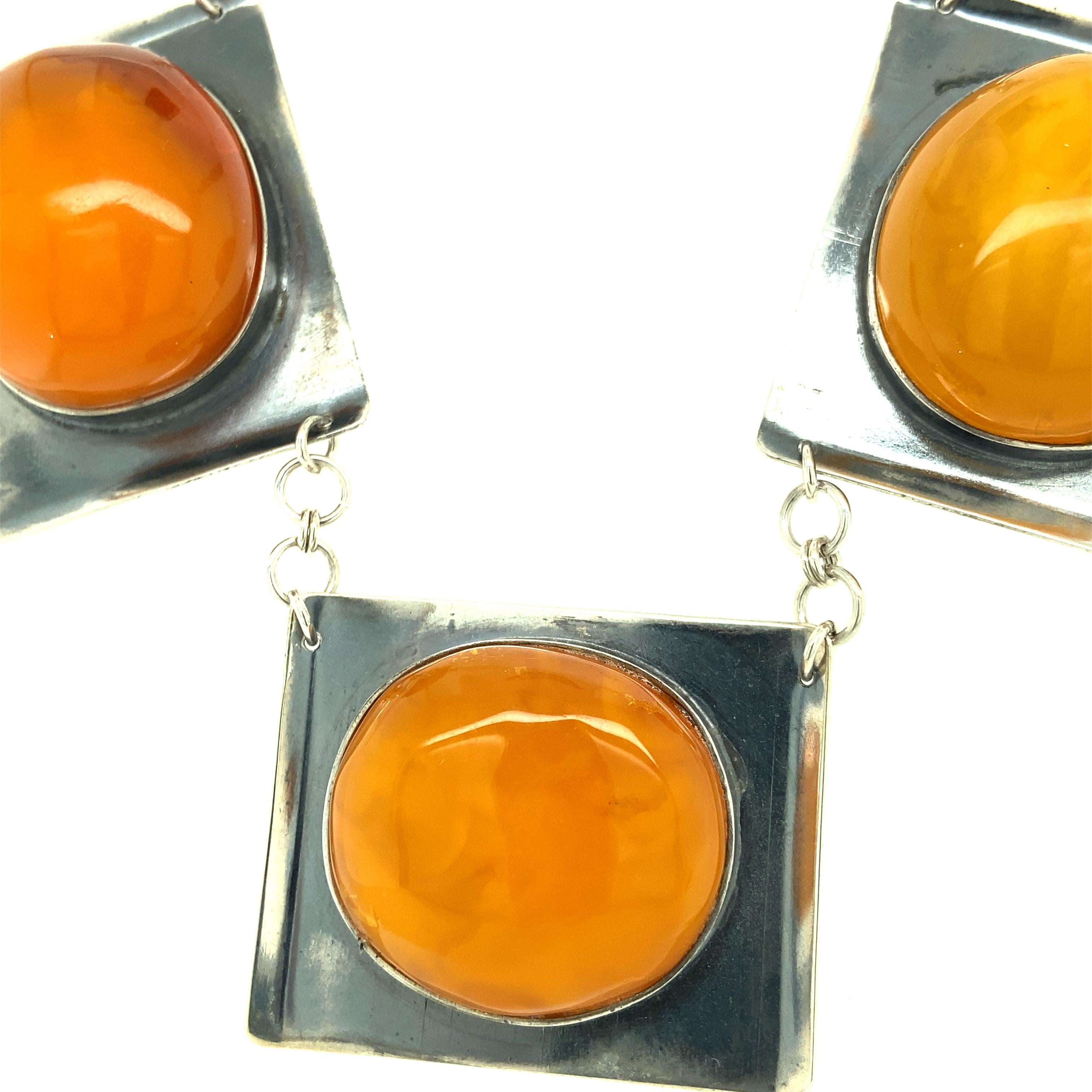 One sterling silver (stamped 875 K8) necklace set with three 25.17x22.18mm cabochon oval amber stones.  The necklace measures 18 inches long and is complete with a hook clasp closure.  